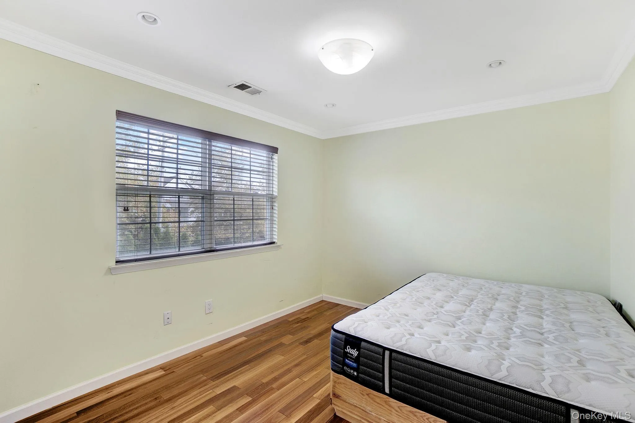 Bedroom with crown molding and wood finished floors Bedroom with crown molding and wood finished floors