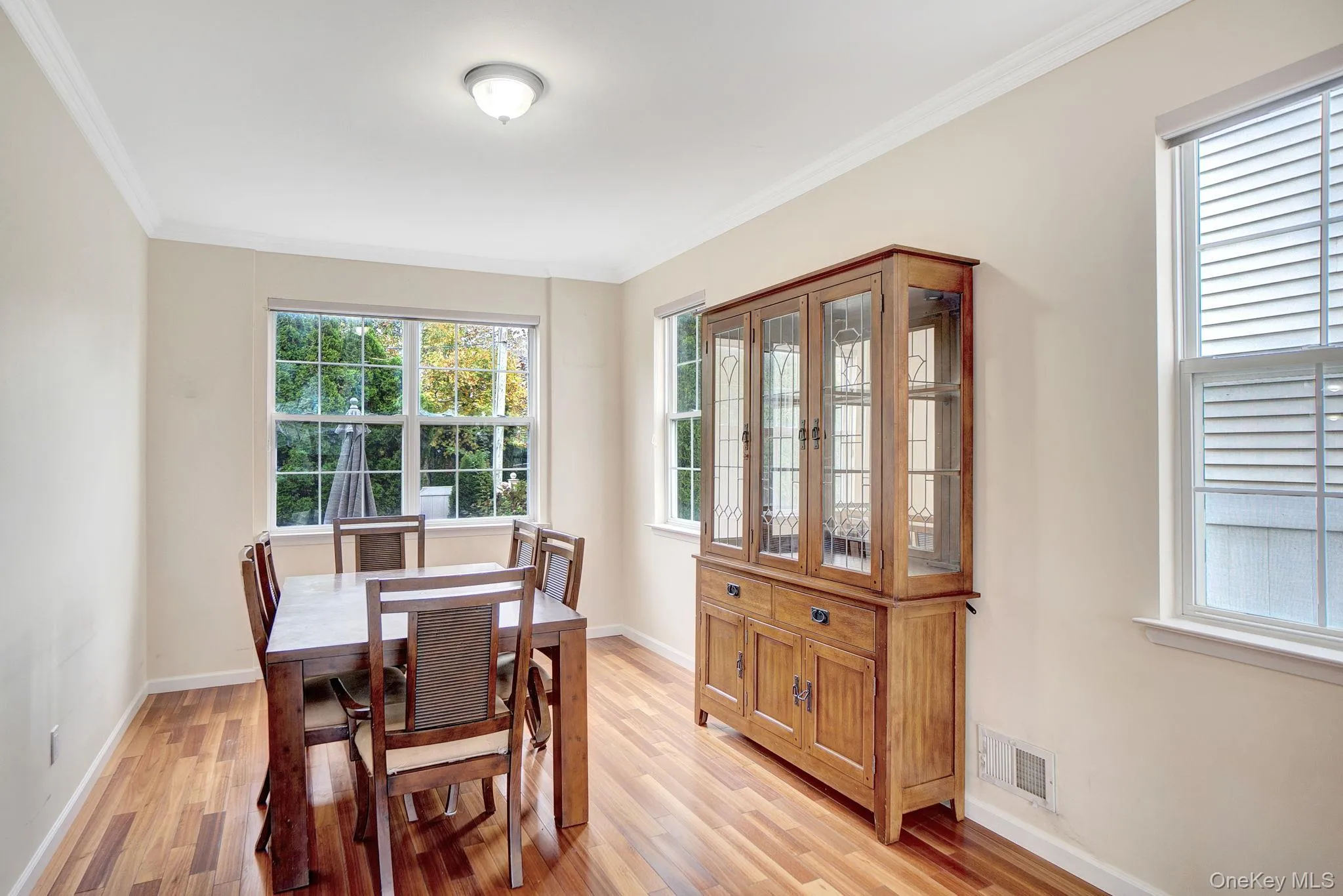 Dining room with ornamental molding and light wood-style flooring Dining room with ornamental molding and light wood-style flooring
