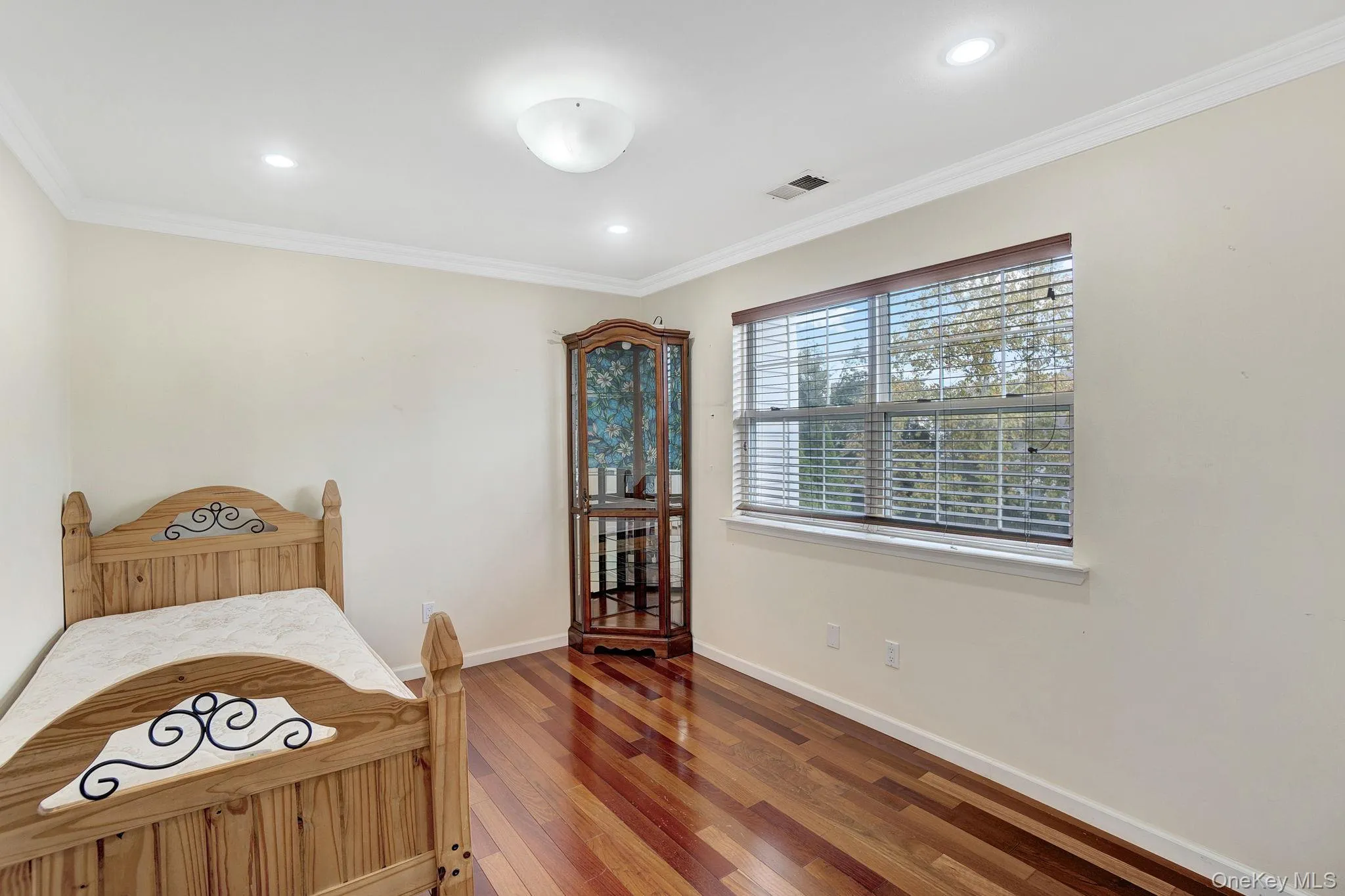 Bedroom featuring ornamental molding, wood finished floors, and recessed lighting Bedroom featuring ornamental molding, wood finished floors, and recessed lighting