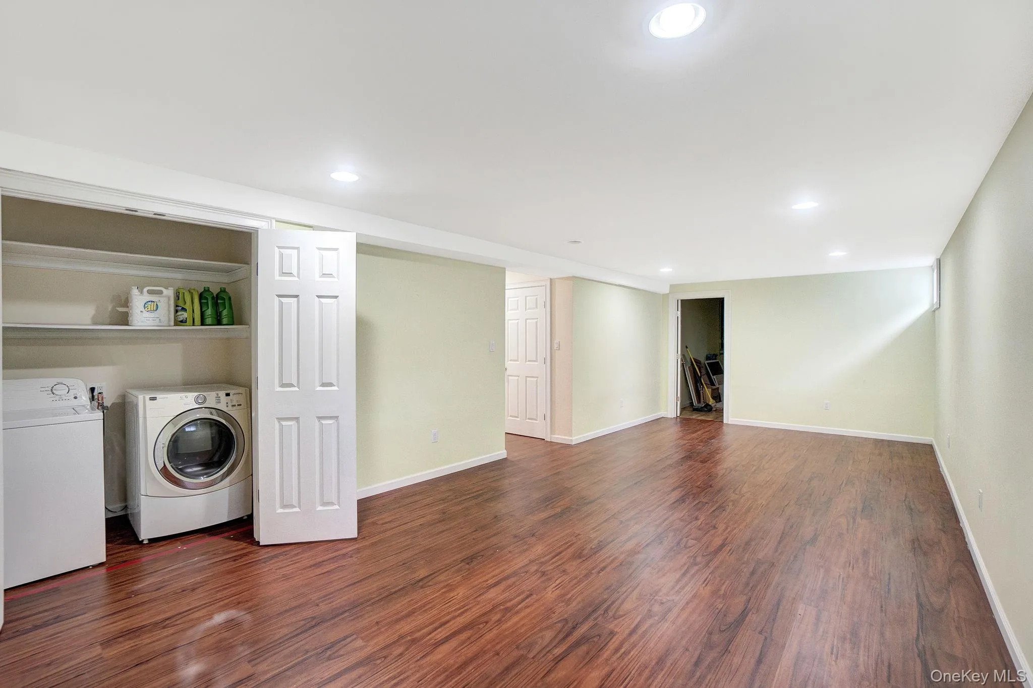 Laundry room with recessed lighting, washer and dryer, and dark wood-style flooring Laundry room with recessed lighting, washer and dryer, and dark wood-style flooring