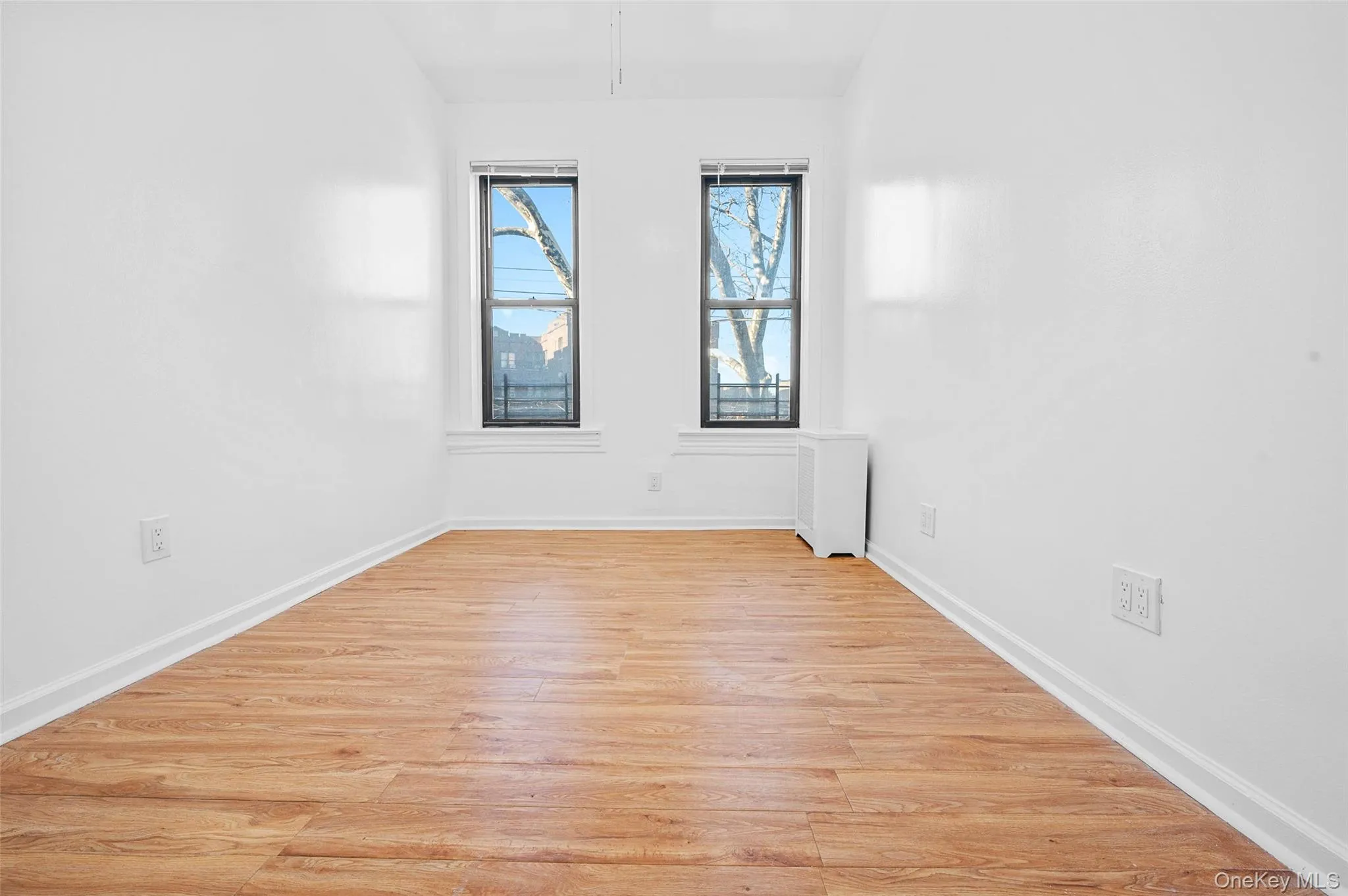 Unfurnished room with light wood-type flooring and baseboards Unfurnished room with light wood-type flooring and baseboards