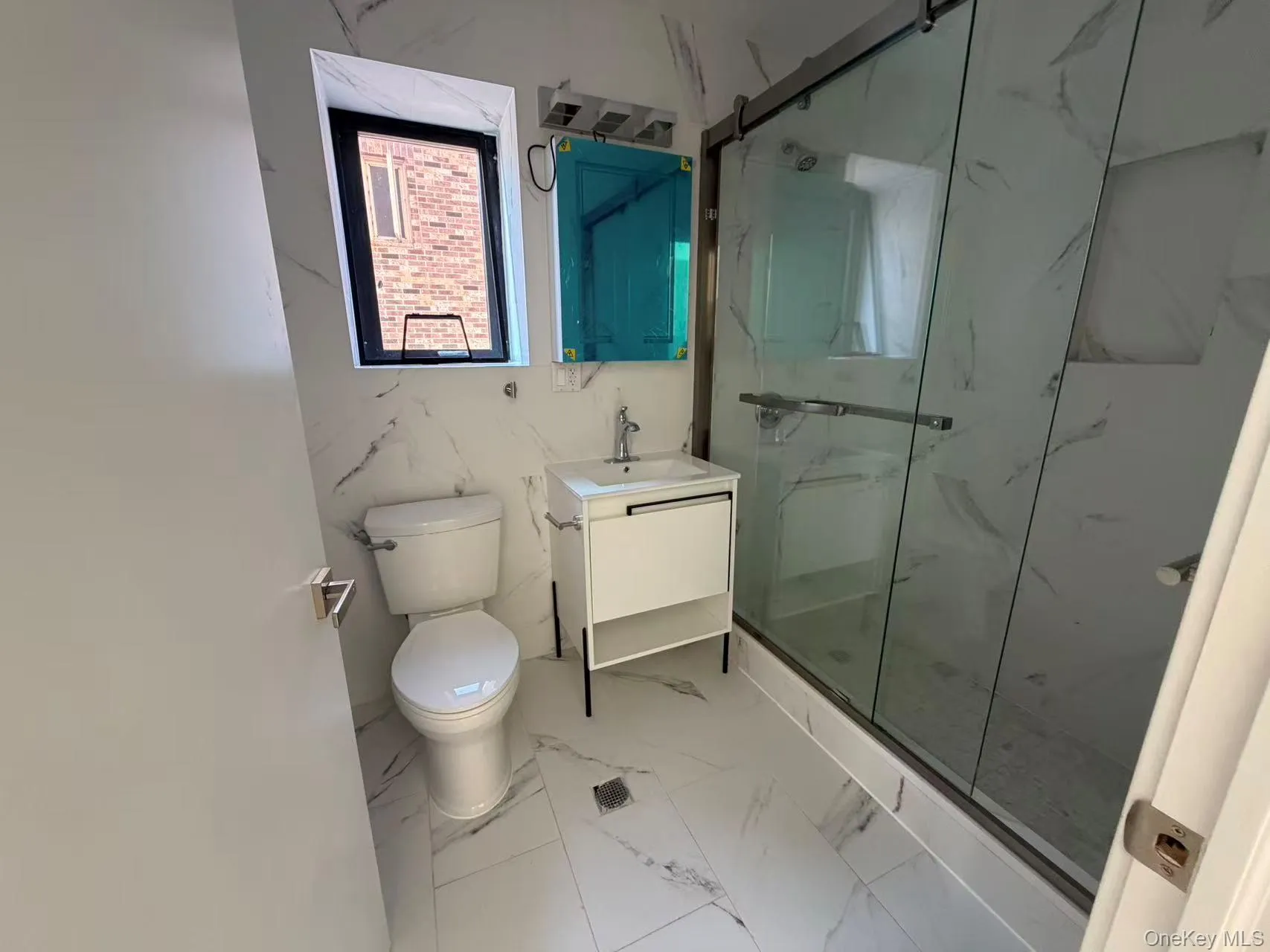 Bathroom featuring a marble finish shower, vanity, and marble finish floors Bathroom featuring a marble finish shower, vanity, and marble finish floors