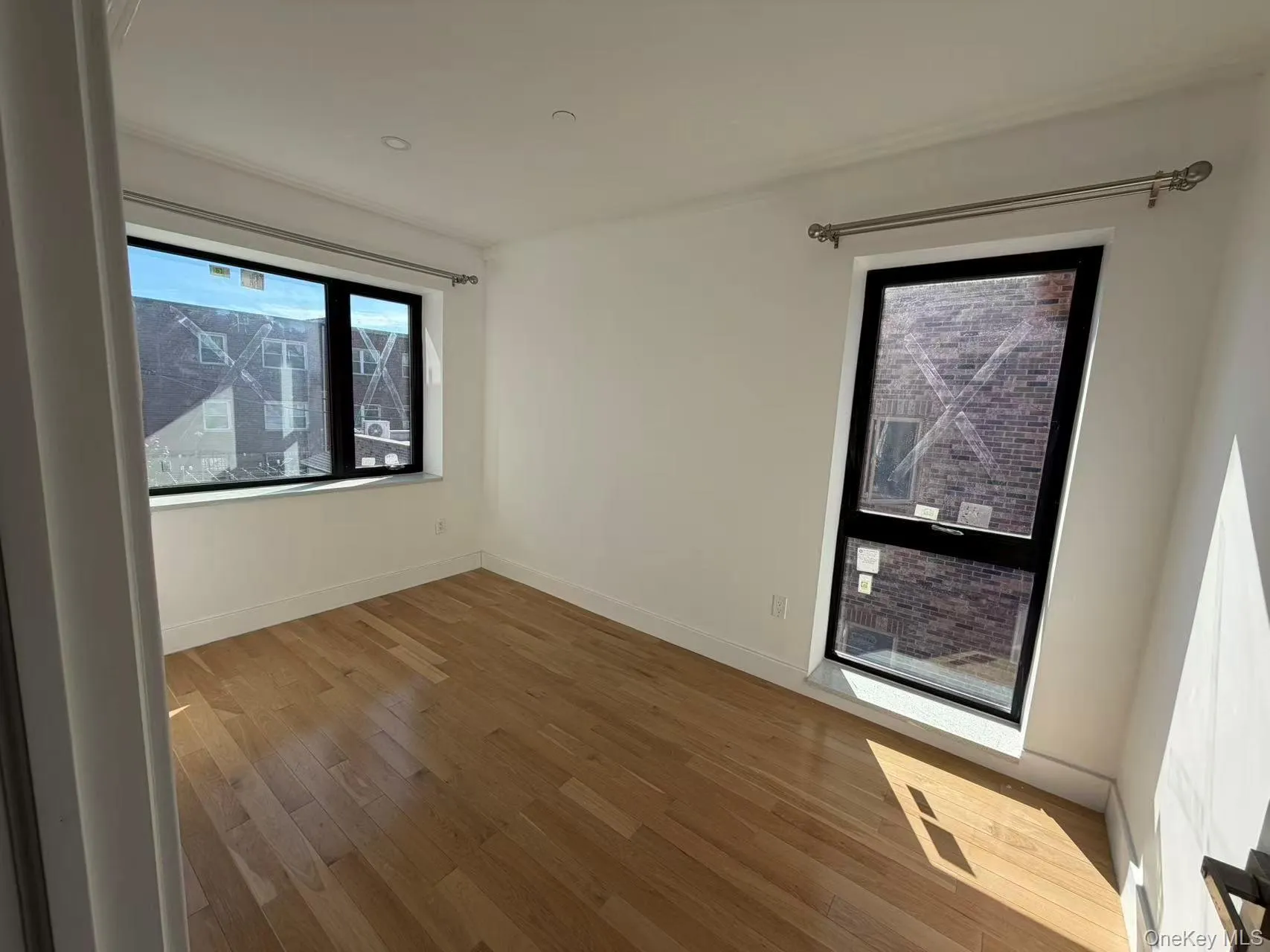 Spare room featuring light wood-style floors and baseboards Spare room featuring light wood-style floors and baseboards