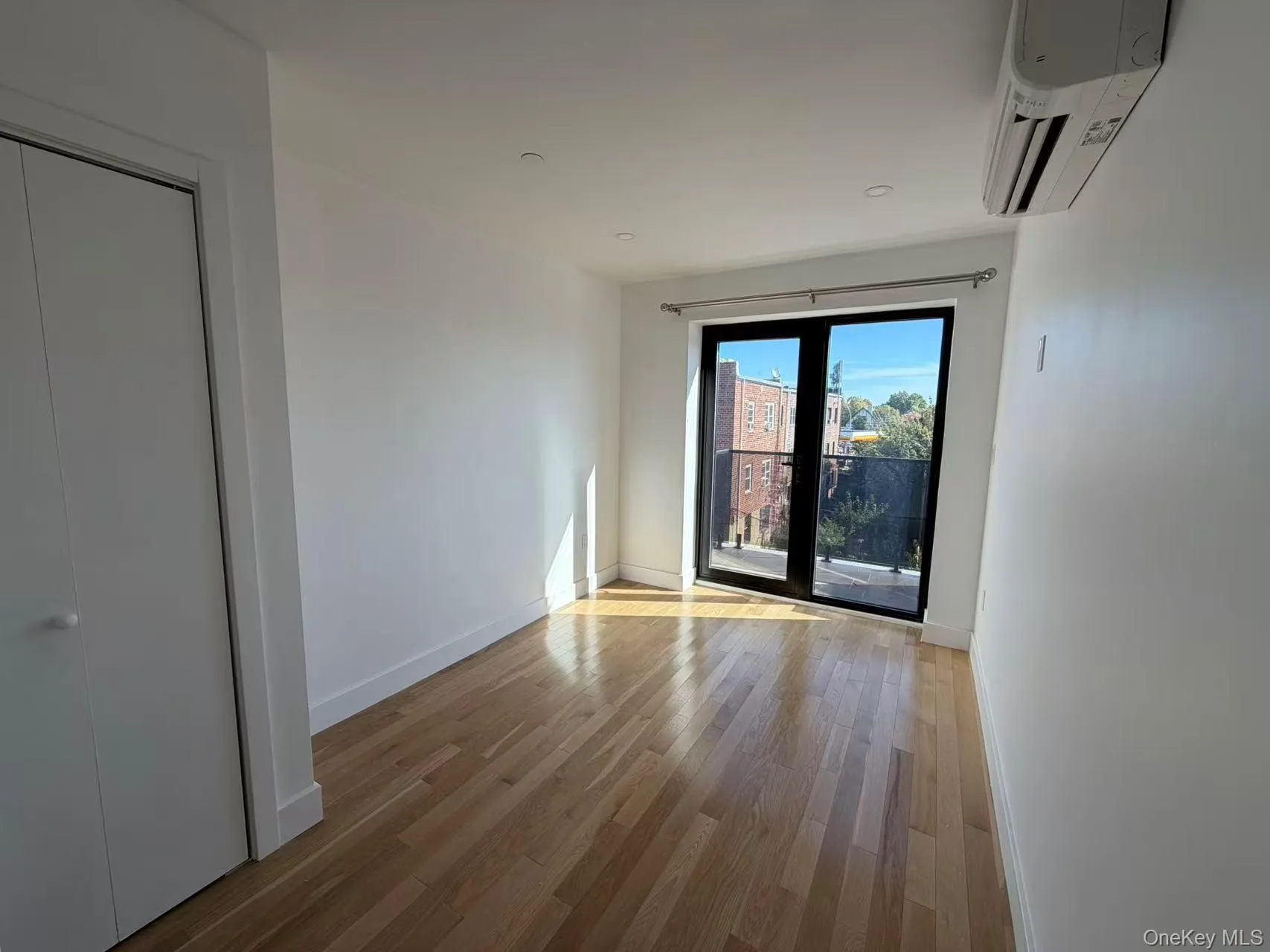 Empty room featuring light wood-type flooring, an AC wall unit, and recessed lighting Empty room featuring light wood-type flooring, an AC wall unit, and recessed lighting