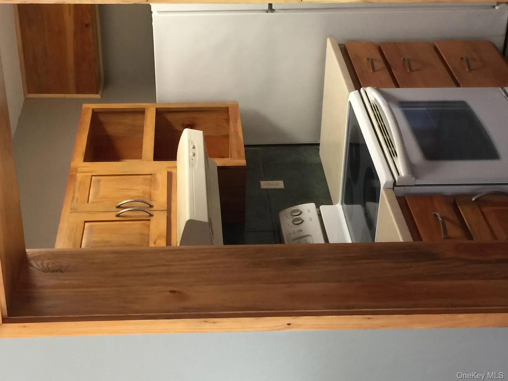 Kitchen with white range oven, brown cabinetry, and exhaust hood Kitchen with white range oven, brown cabinetry, and exhaust hood