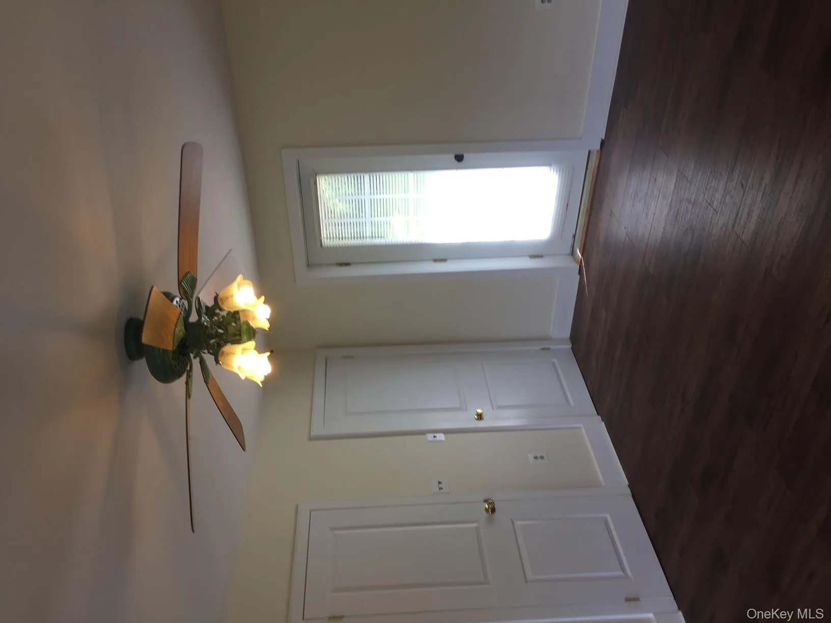 Spare room featuring dark wood-type flooring and ceiling fan Spare room featuring dark wood-type flooring and ceiling fan