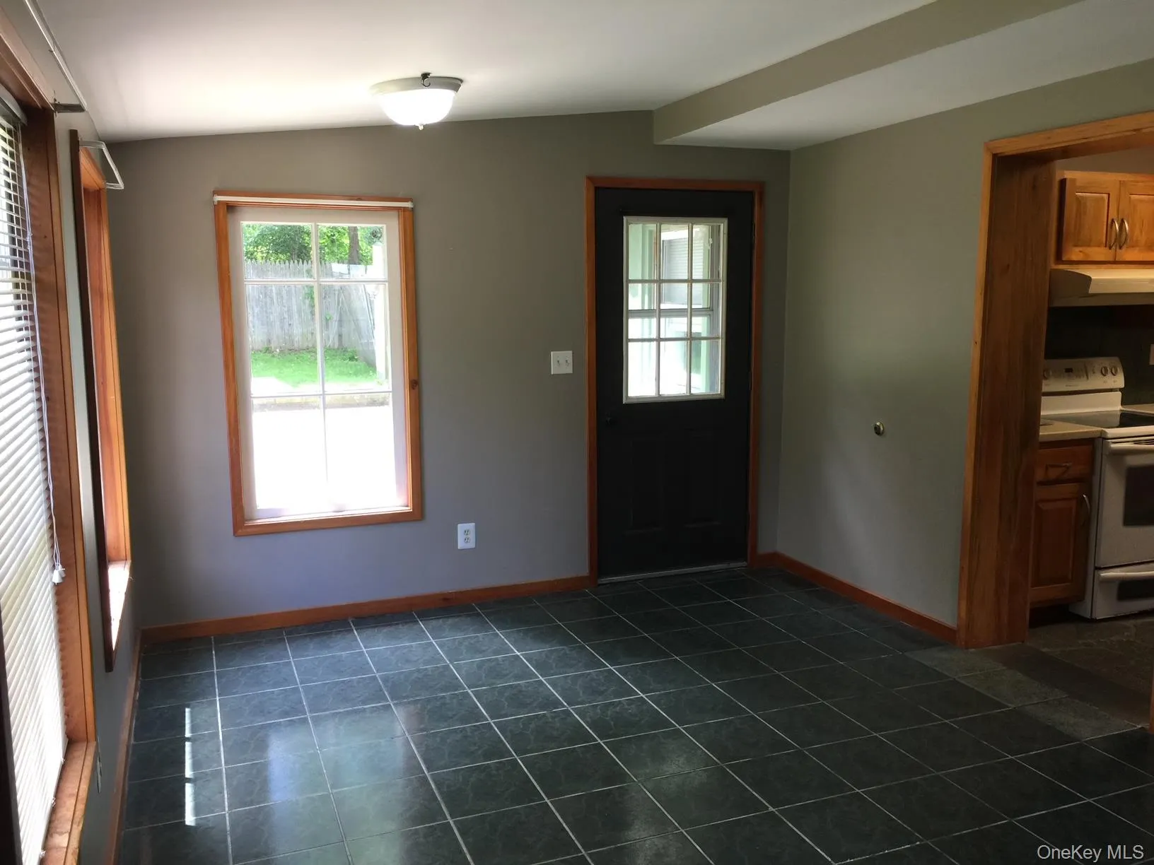 Foyer featuring healthy amount of natural light and dark tile patterned flooring Foyer featuring healthy amount of natural light and dark tile patterned flooring