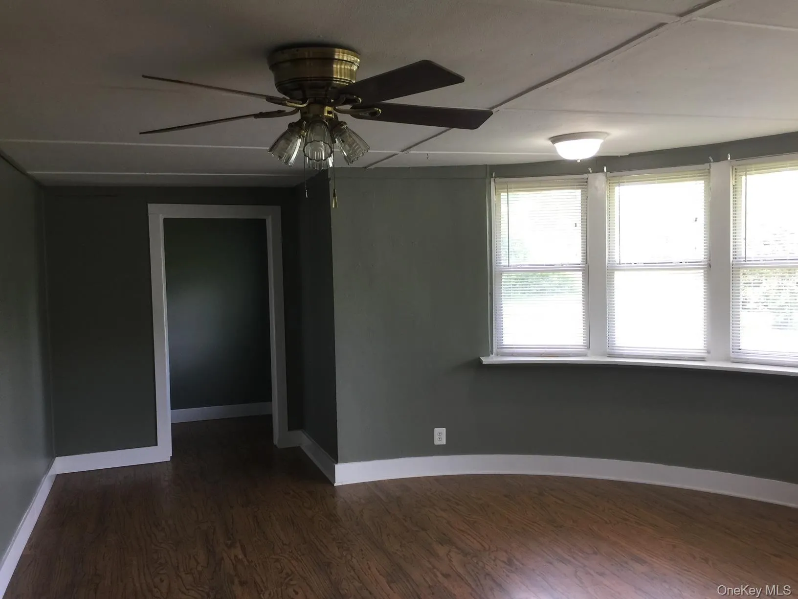 Spare room with dark wood-style flooring and ceiling fan Spare room with dark wood-style flooring and ceiling fan