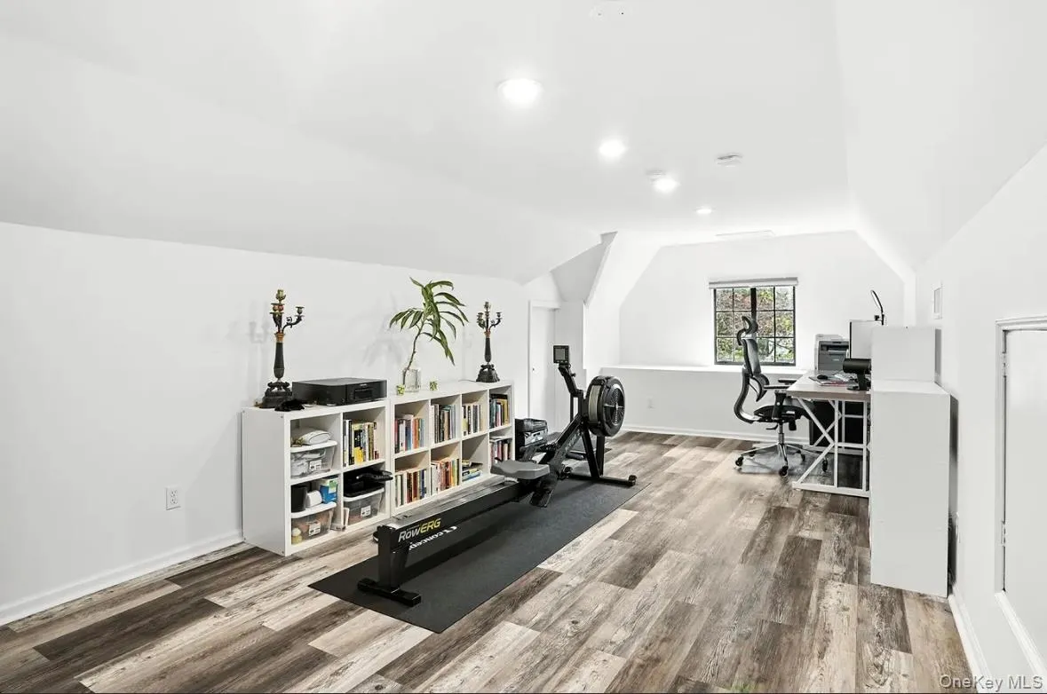Workout room with light wood-style floors and lofted ceiling Workout room with light wood-style floors and lofted ceiling