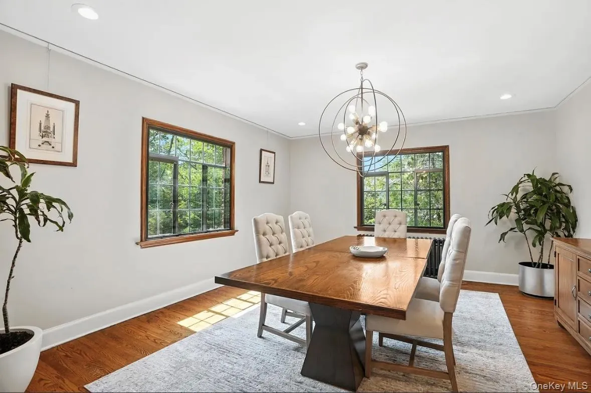 Dining room with dark wood finished floors, plenty of natural light, recessed lighting, crown molding, and a chandelier Dining room with dark wood finished floors, plenty of natural light, recessed lighting, crown molding, and a chandelier