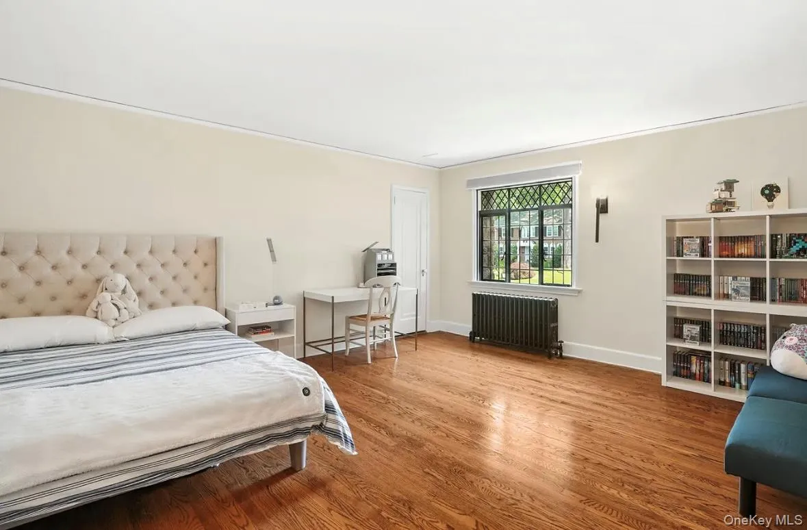 Bedroom with radiator and wood finished floors Bedroom with radiator and wood finished floors
