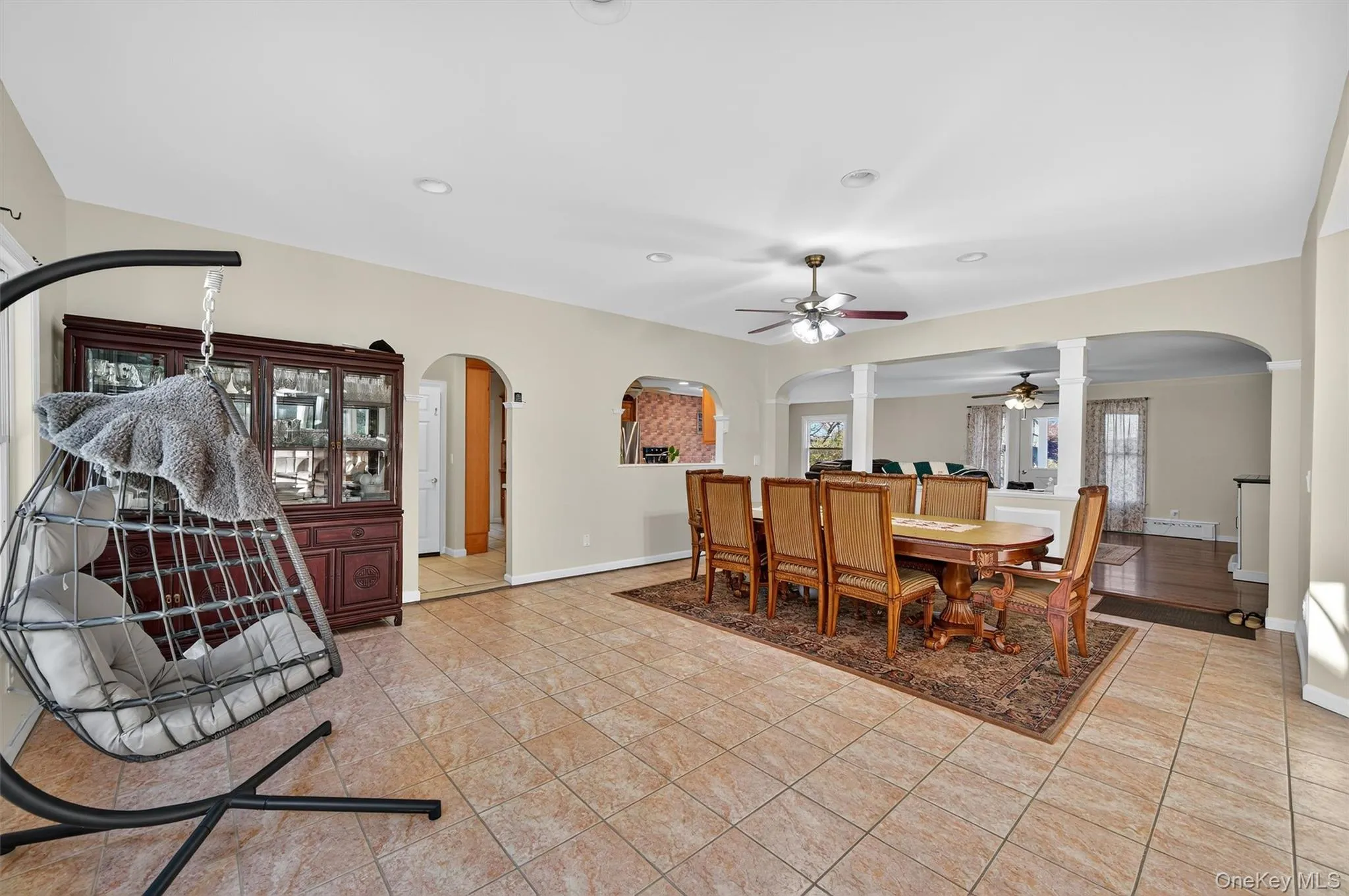 Dining space with arched walkways, a ceiling fan, light tile patterned floors, and recessed lighting Dining space with arched walkways, a ceiling fan, light tile patterned floors, and recessed lighting