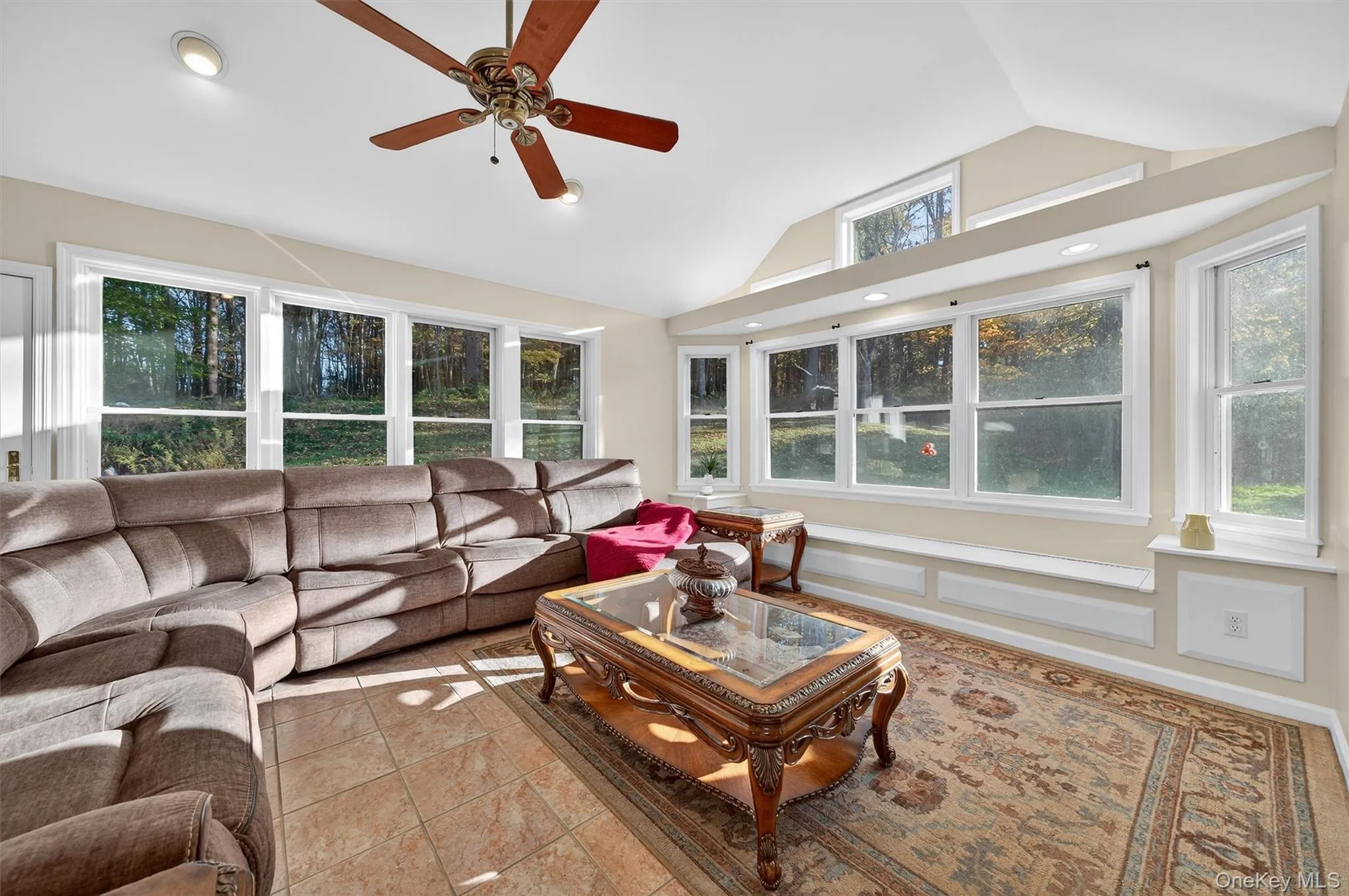Living room featuring lofted ceiling, tile patterned floors, a ceiling fan, and recessed lighting Living room featuring lofted ceiling, tile patterned floors, a ceiling fan, and recessed lighting