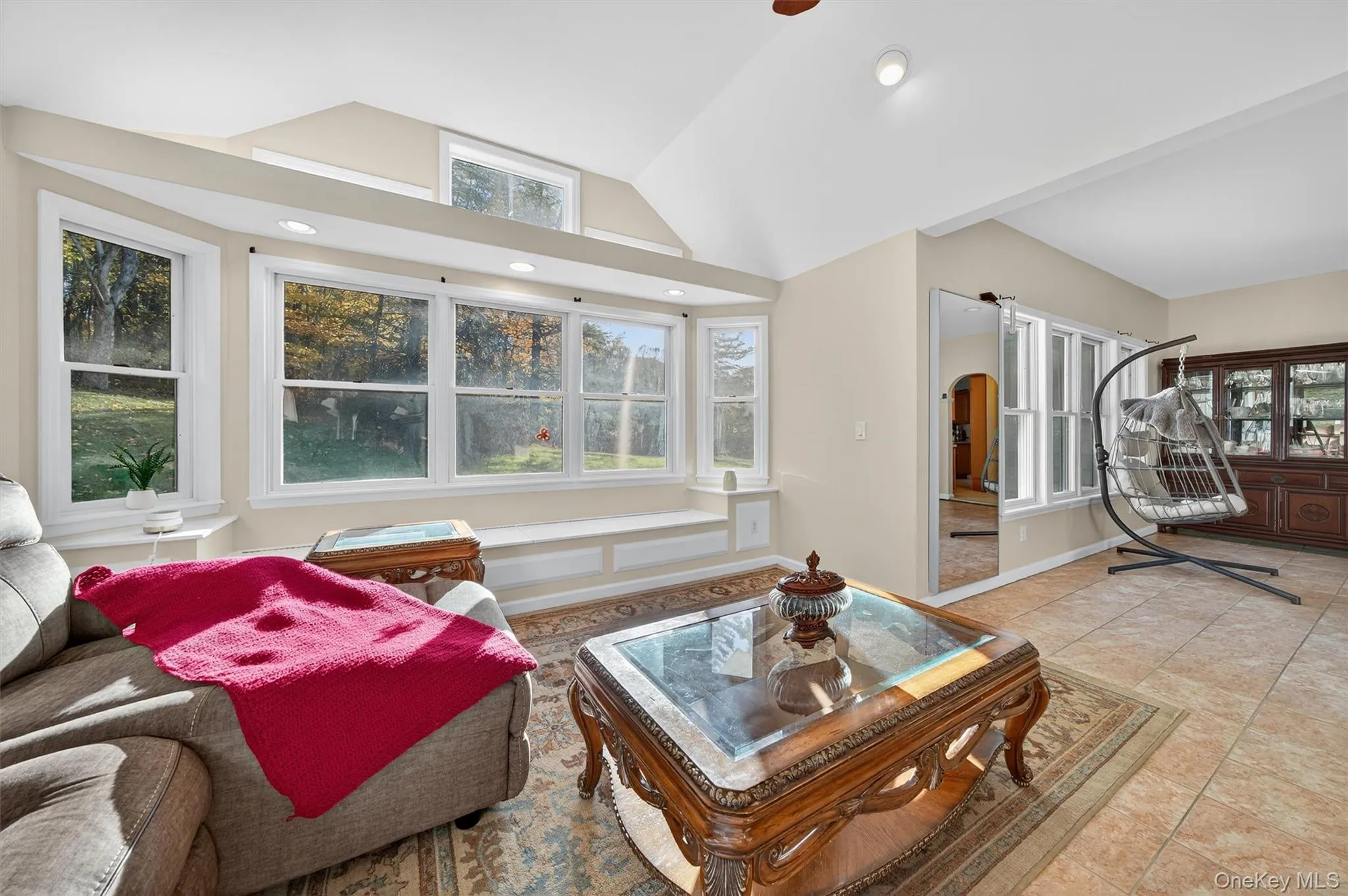 Living room with vaulted ceiling, arched walkways, recessed lighting, and tile patterned flooring Living room with vaulted ceiling, arched walkways, recessed lighting, and tile patterned flooring