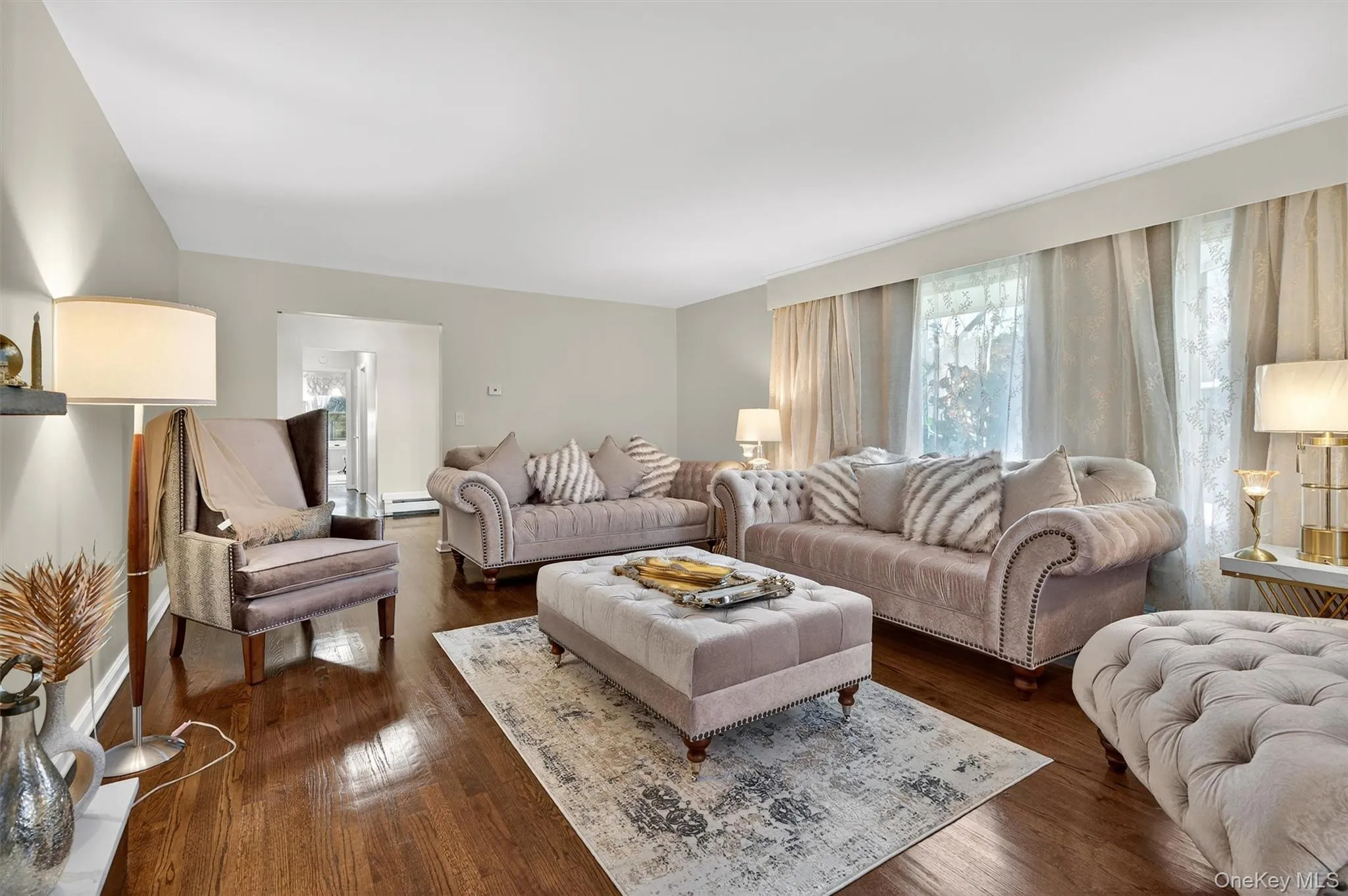 Formal Living room featuring dark wood finished floors and baseboard heating & Fireplace Formal Living room featuring dark wood finished floors and baseboard heating & Fireplace