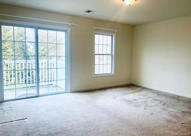 Empty room featuring carpet flooring and baseboards Empty room featuring carpet flooring and baseboards