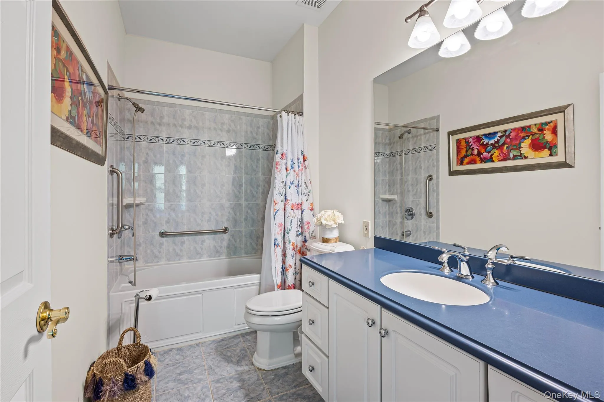 Full bathroom featuring vanity, shower / bath combo, and dark tile patterned flooring Full bathroom featuring vanity, shower / bath combo, and dark tile patterned flooring