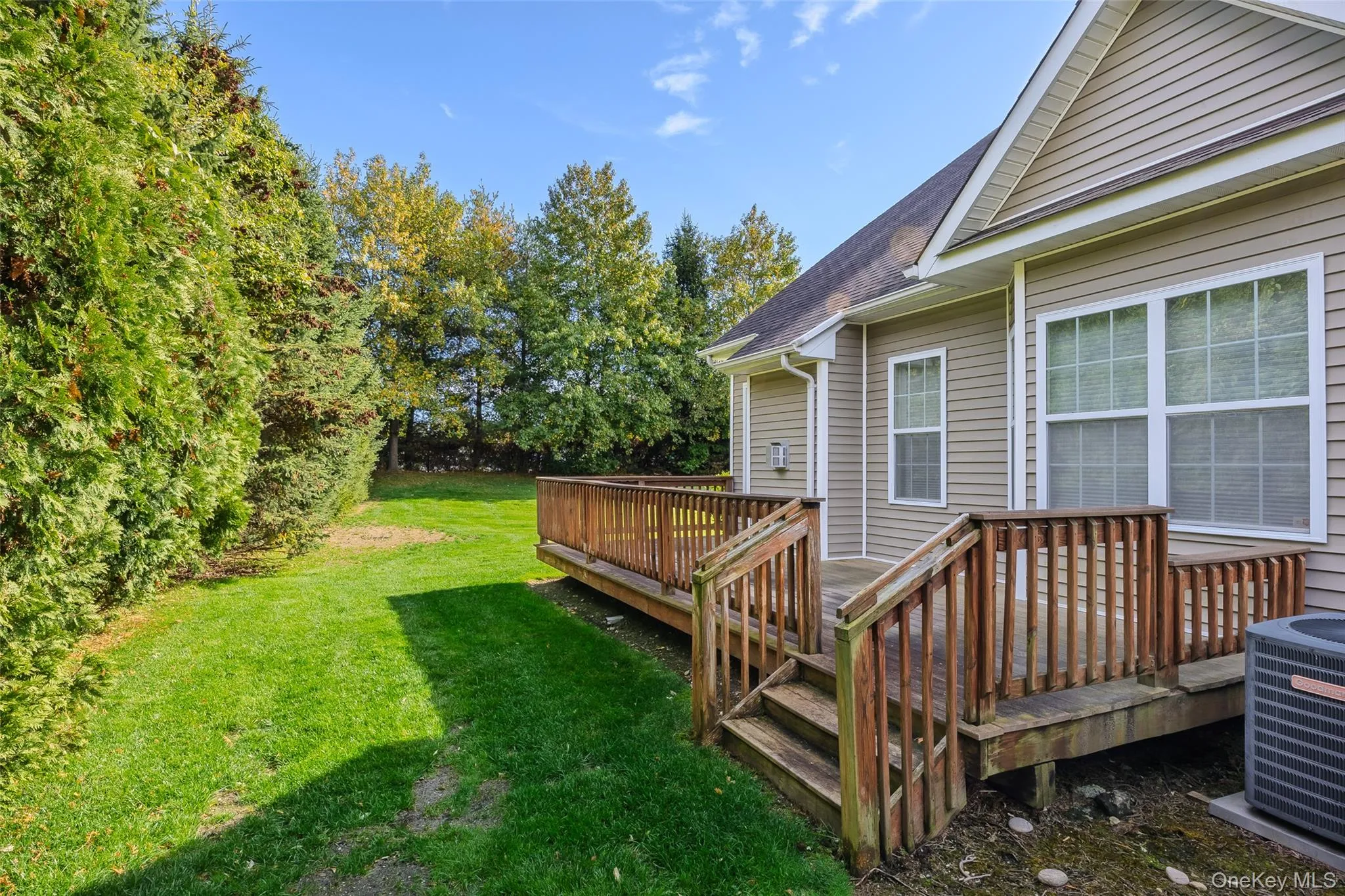 View of green lawn featuring a wooden deck View of green lawn featuring a wooden deck