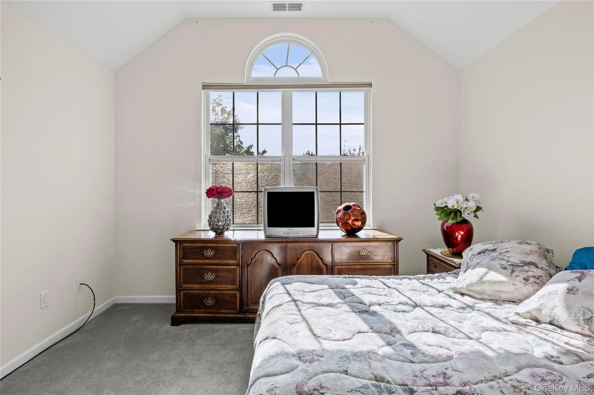 Bedroom with lofted ceiling and light colored carpet Bedroom with lofted ceiling and light colored carpet