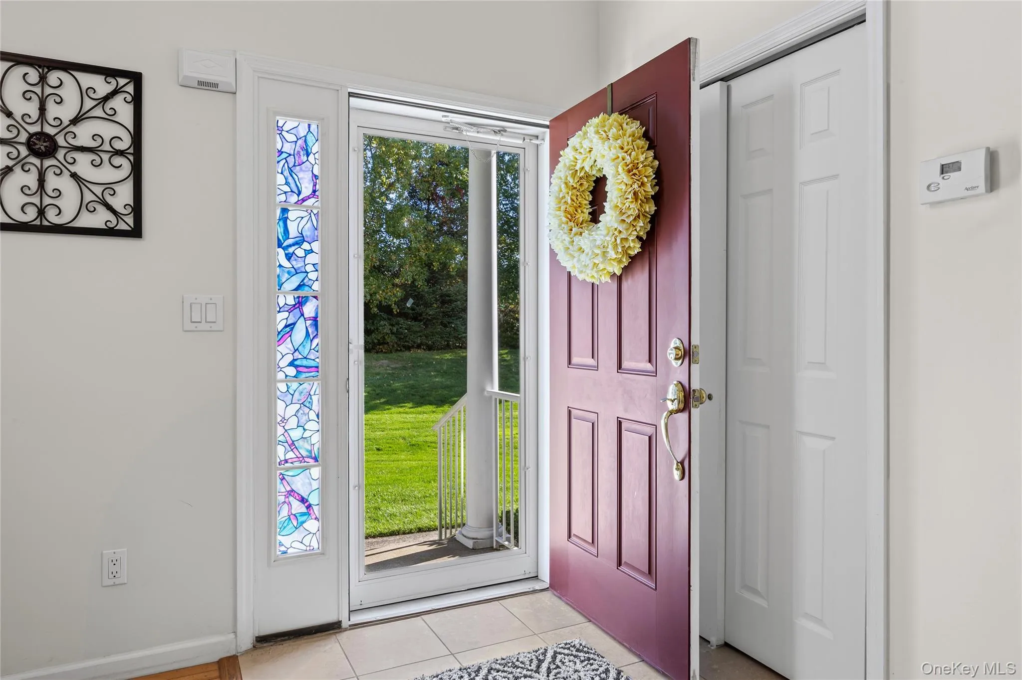 Entrance foyer with light tile patterned floors and baseboards Entrance foyer with light tile patterned floors and baseboards