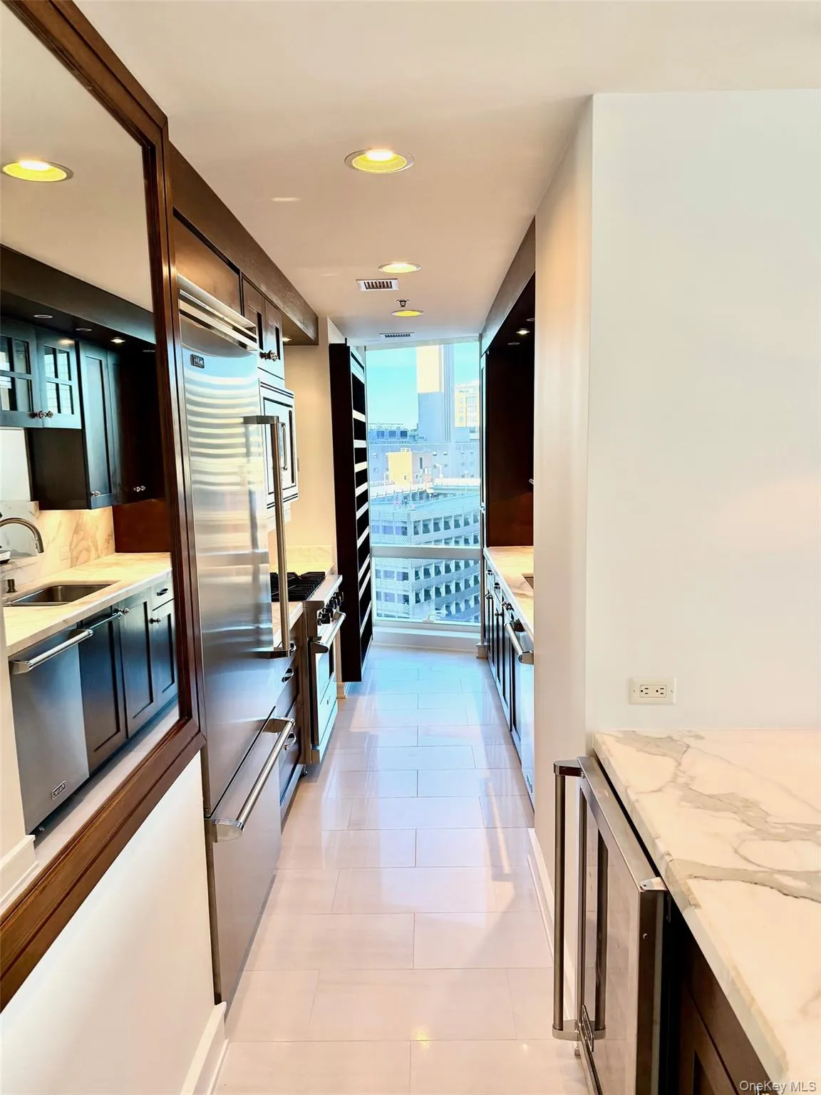 Kitchen with light tile patterned floors, light stone countertops, high end appliances, wine cooler, and recessed lighting Kitchen with light tile patterned floors, light stone countertops, high end appliances, wine cooler, and recessed lighting