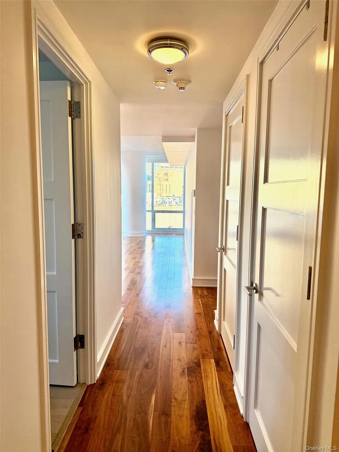 Corridor featuring dark wood-type flooring and baseboards Corridor featuring dark wood-type flooring and baseboards