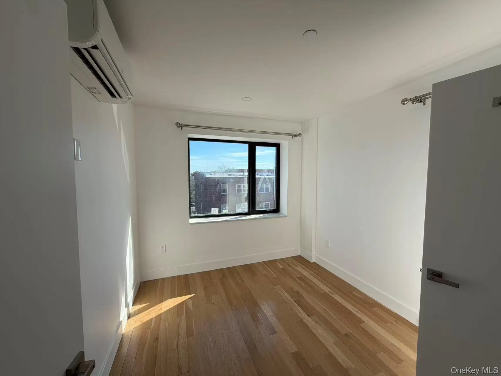 Spare room featuring light wood-style floors and a wall mounted AC Spare room featuring light wood-style floors and a wall mounted AC