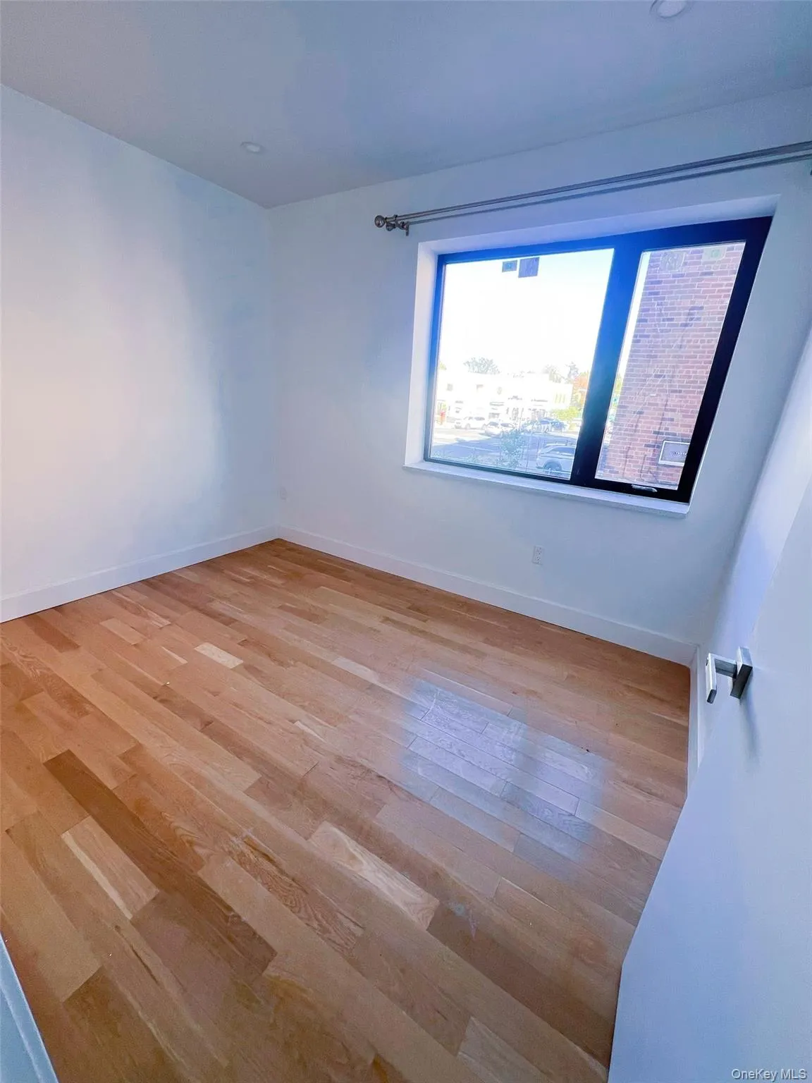 Empty room with baseboards and light wood-style flooring Empty room with baseboards and light wood-style flooring