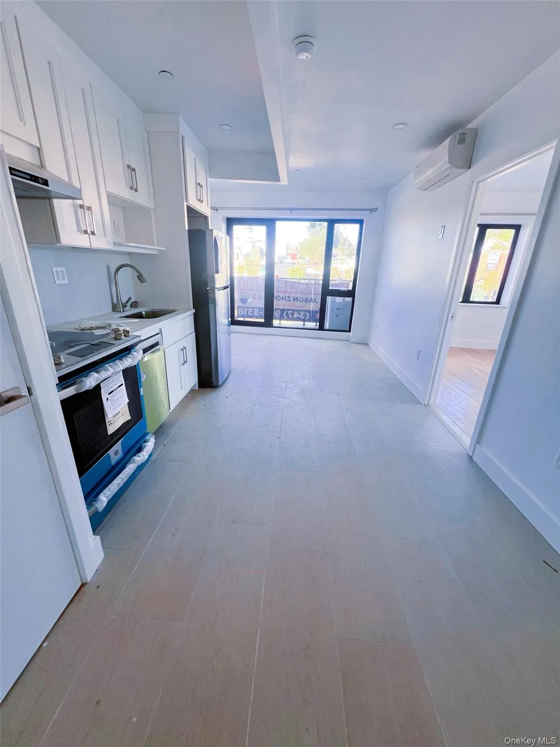 Kitchen with white cabinetry, appliances with stainless steel finishes, light wood-style flooring, healthy amount of natural light, and beamed ceiling Kitchen with white cabinetry, appliances with stainless steel finishes, light wood-style flooring, healthy amount of natural light, and beamed ceiling