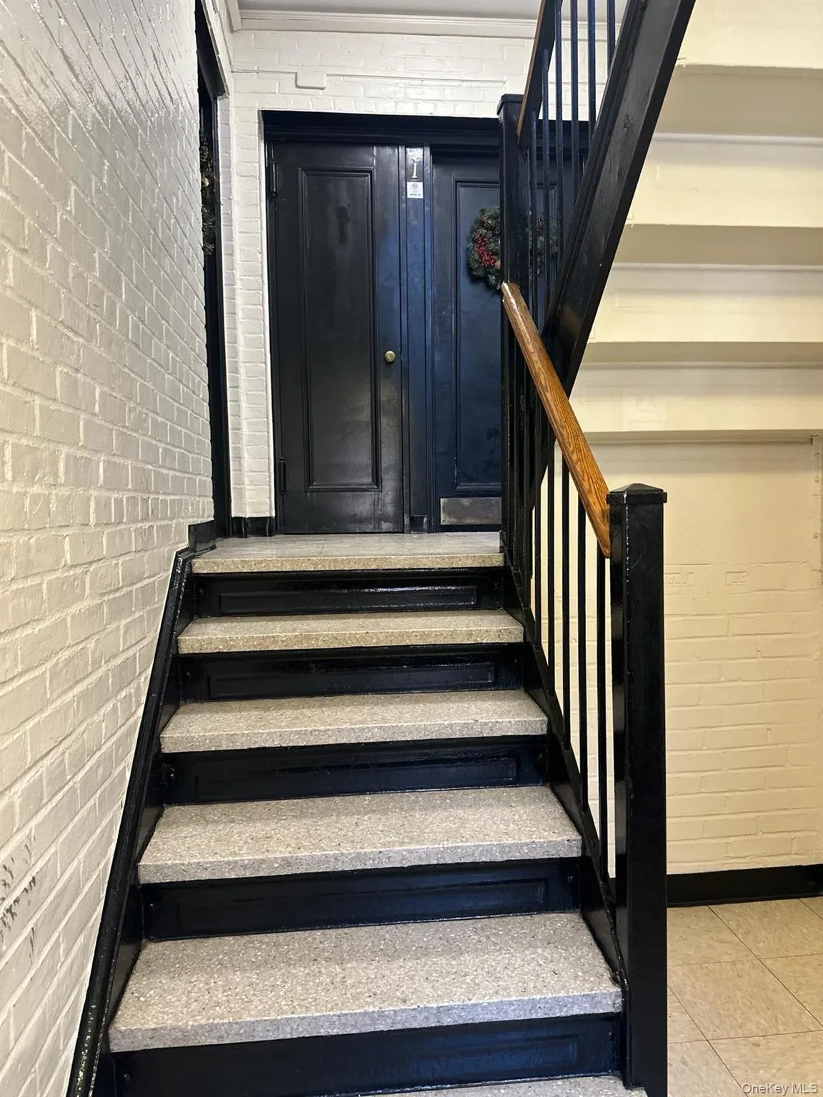 Stairs with brick wall and tile patterned flooring Stairs with brick wall and tile patterned flooring