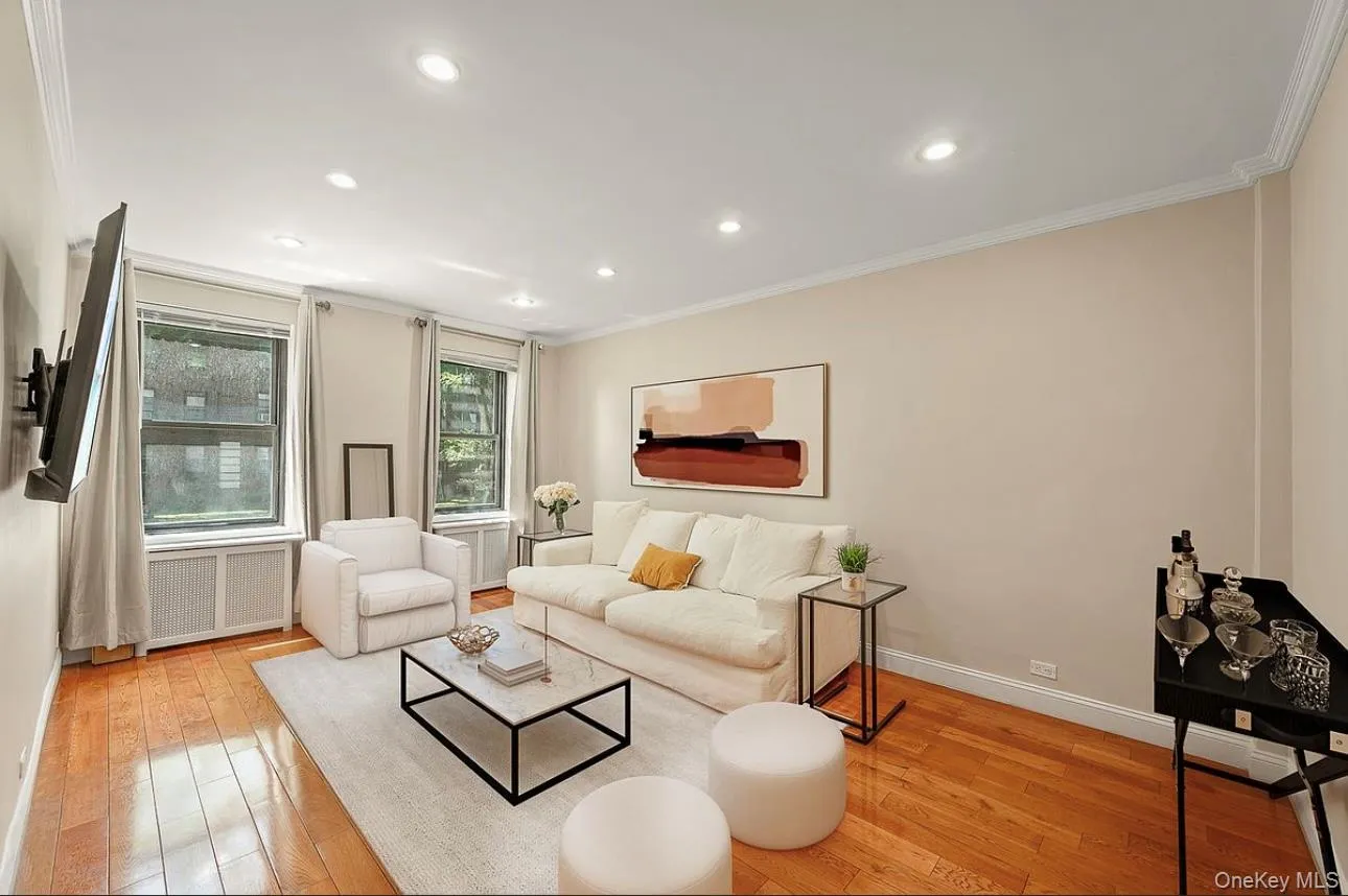 Living room featuring ornamental molding, light wood finished floors, recessed lighting, and radiator Living room featuring ornamental molding, light wood finished floors, recessed lighting, and radiator