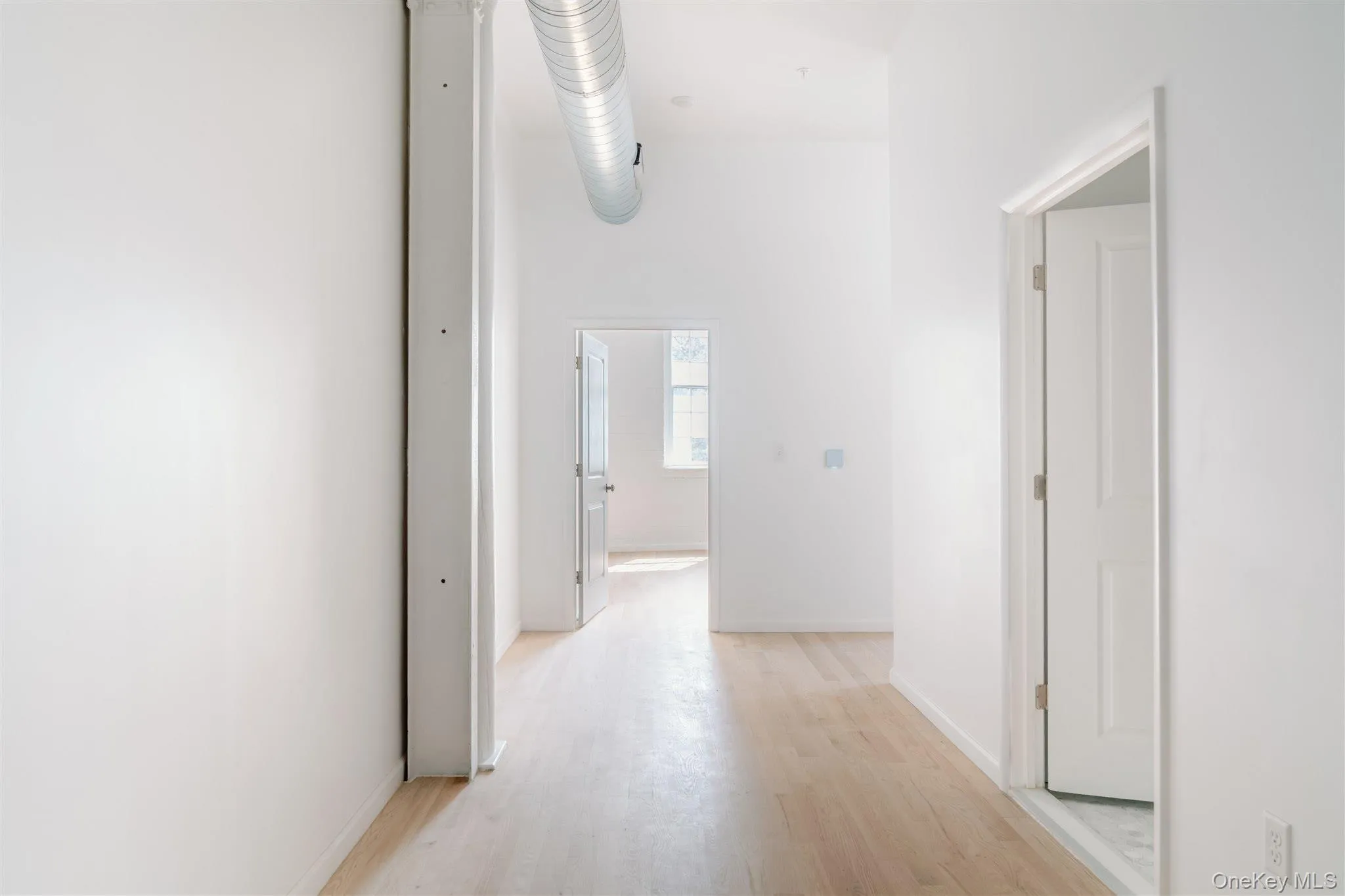 Hall featuring light wood-style floors and baseboards Hall featuring light wood-style floors and baseboards