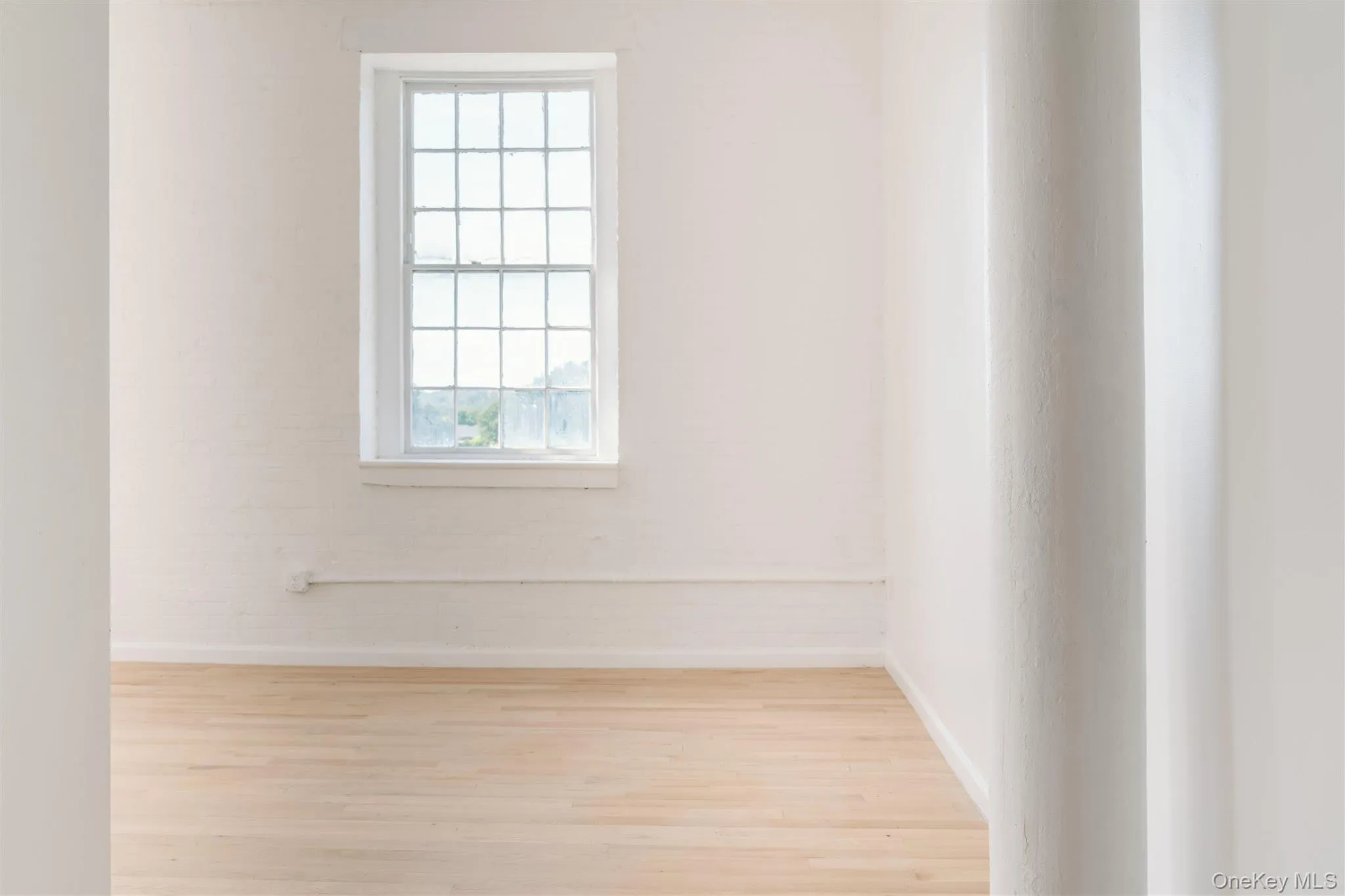 Spare room featuring wood finished floors and baseboards Spare room featuring wood finished floors and baseboards