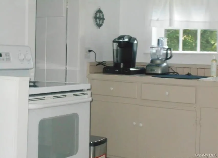 Kitchen featuring electric stove and light countertops Kitchen featuring electric stove and light countertops