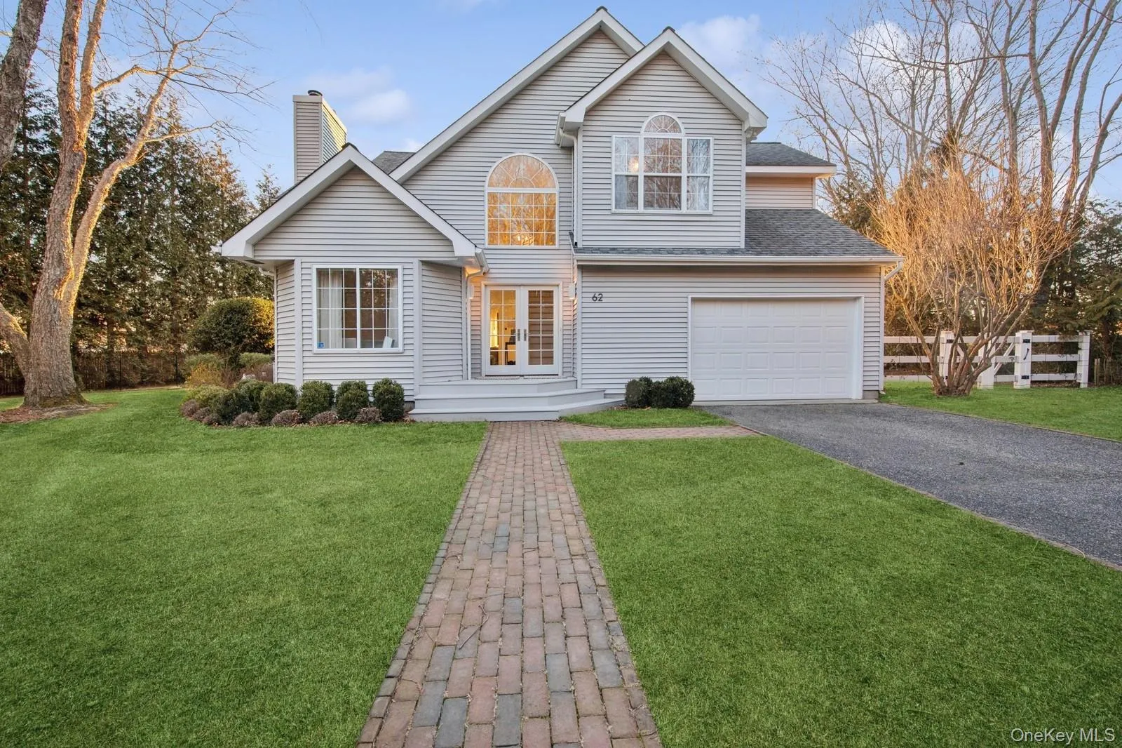 Traditional-style home with driveway, a chimney, and roof with shingles Traditional-style home with driveway, a chimney, and roof with shingles
