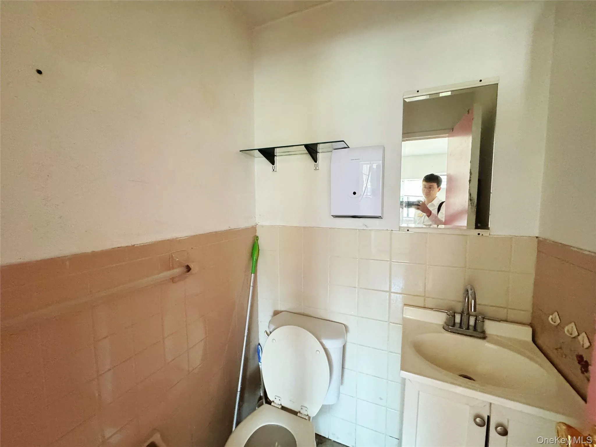 Half bath with tile walls, vanity, and wainscoting Half bath with tile walls, vanity, and wainscoting