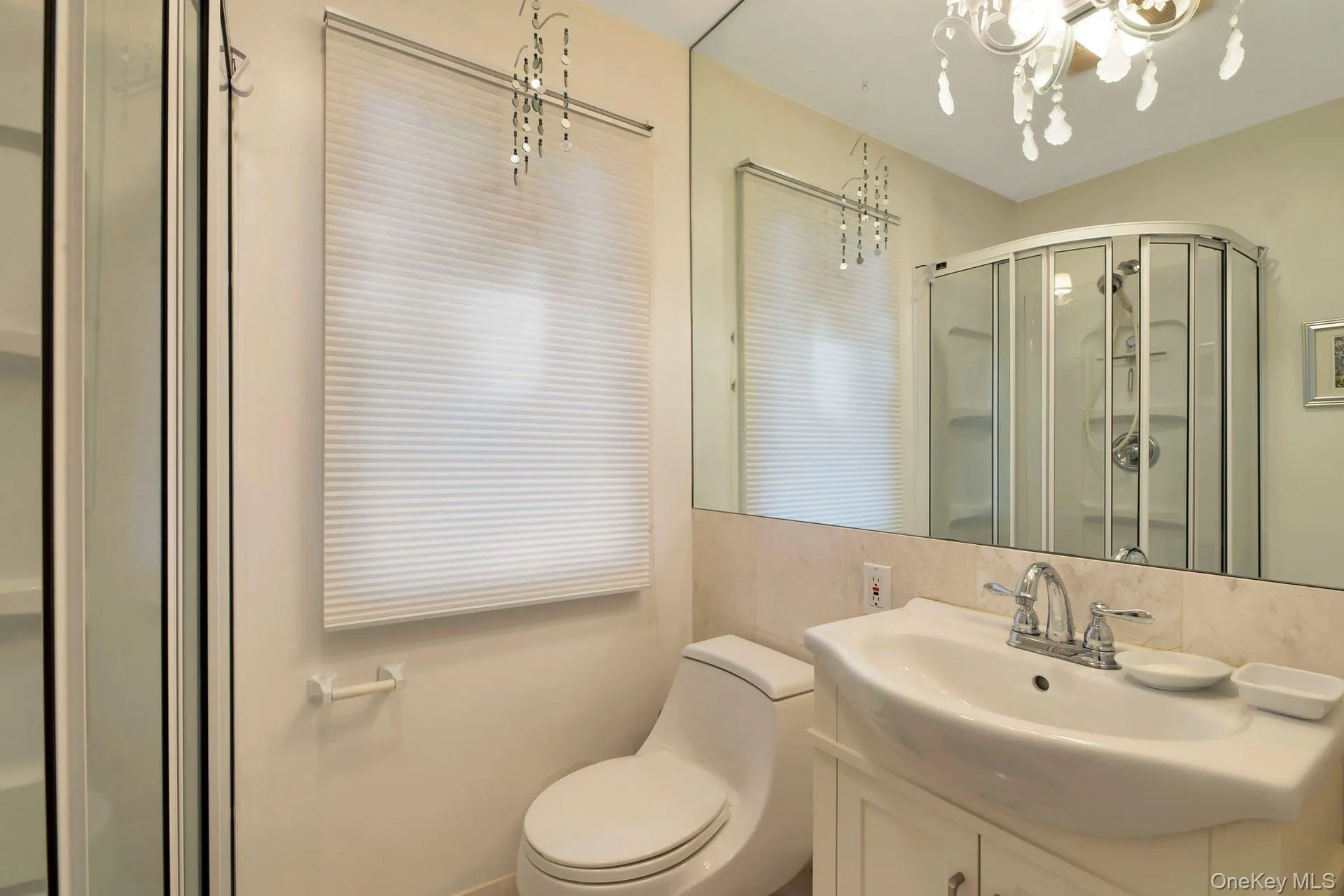 Full bath with vanity, a stall shower, and a chandelier Full bath with vanity, a stall shower, and a chandelier