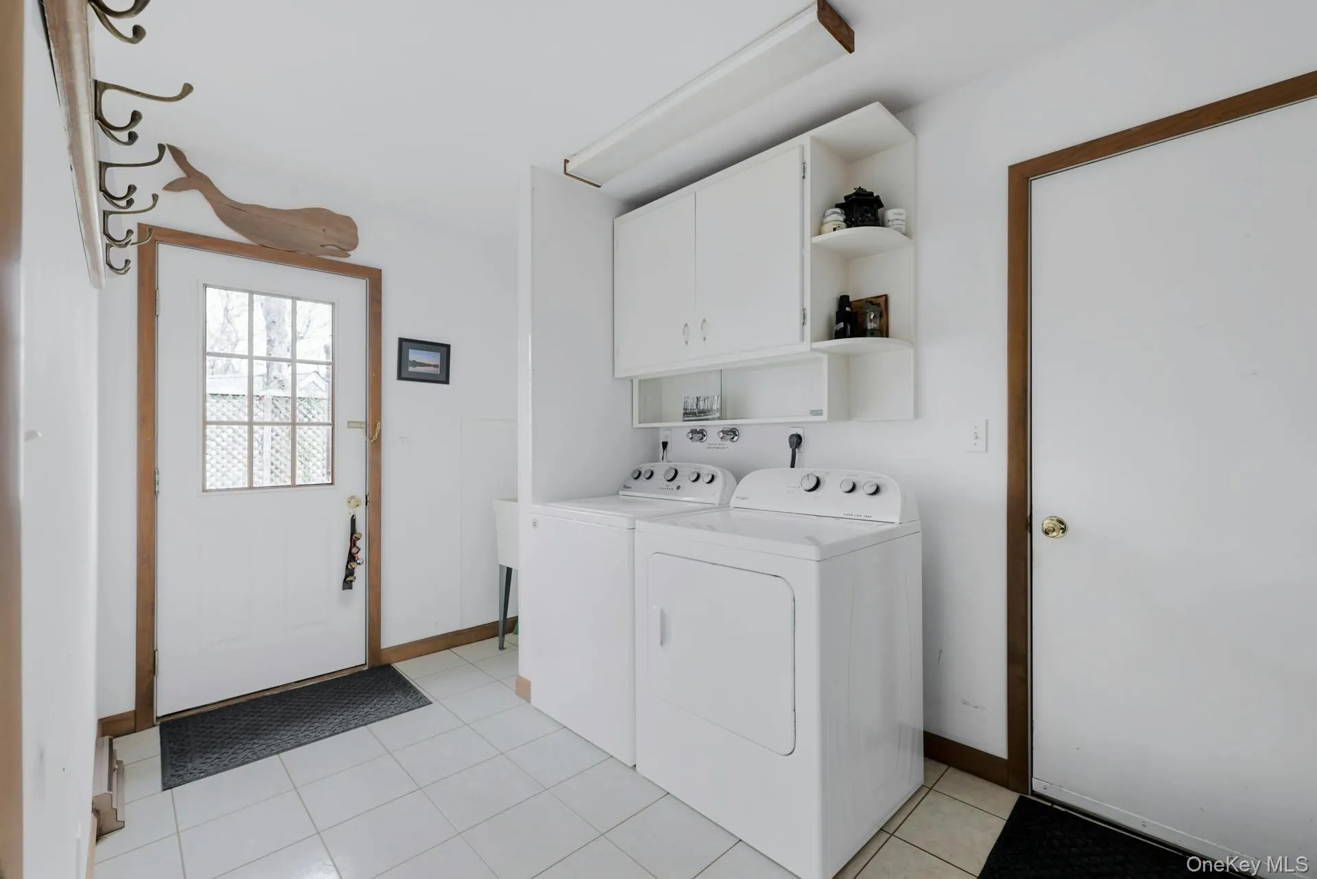 Laundry room with cabinet space, light tile patterned floors, and independent washer and dryer Laundry room with cabinet space, light tile patterned floors, and independent washer and dryer