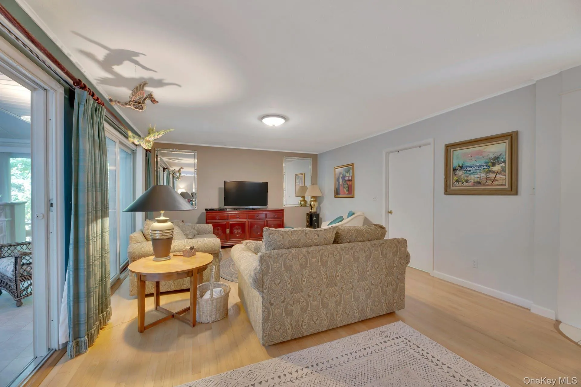 Living area with light wood-style flooring and baseboards Living area with light wood-style flooring and baseboards