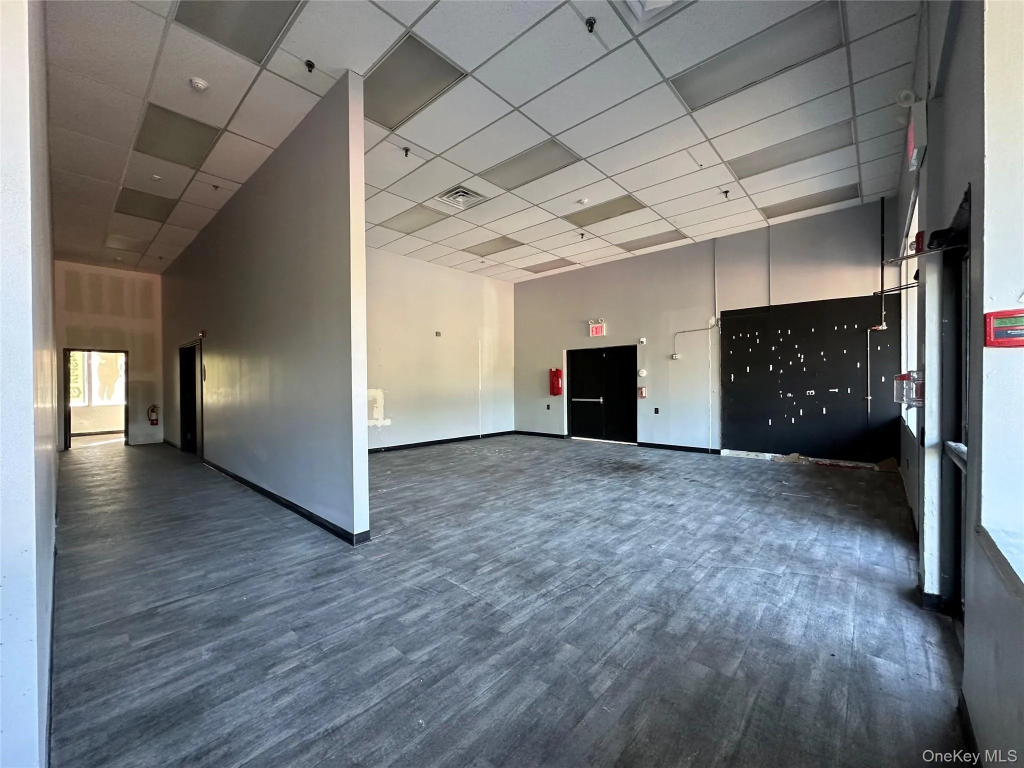 Spare room with dark wood-type flooring, a drop ceiling, and a towering ceiling Spare room with dark wood-type flooring, a drop ceiling, and a towering ceiling