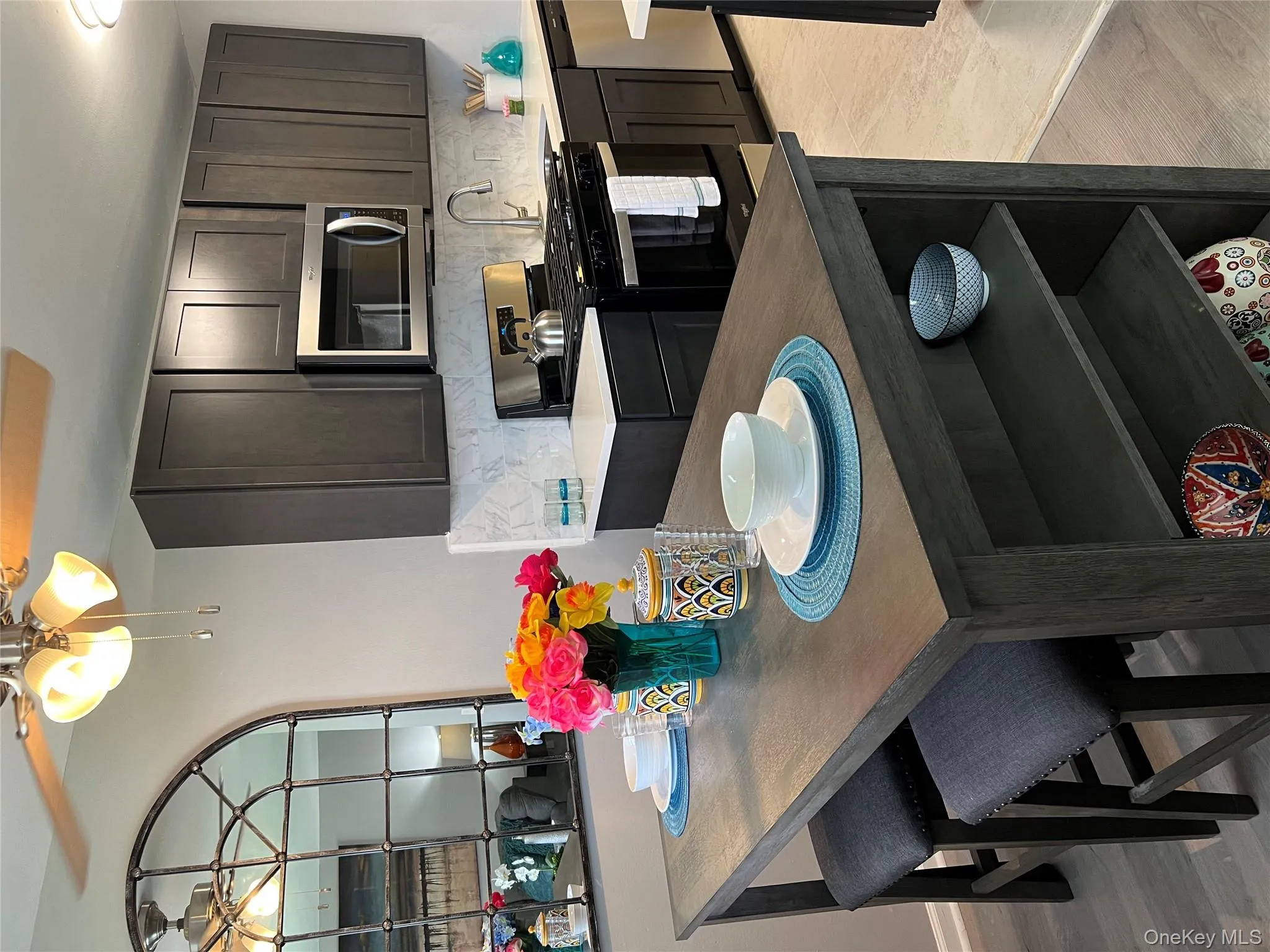 Kitchen featuring stove, decorative backsplash, light wood-style floors, and dishwasher Kitchen featuring stove, decorative backsplash, light wood-style floors, and dishwasher