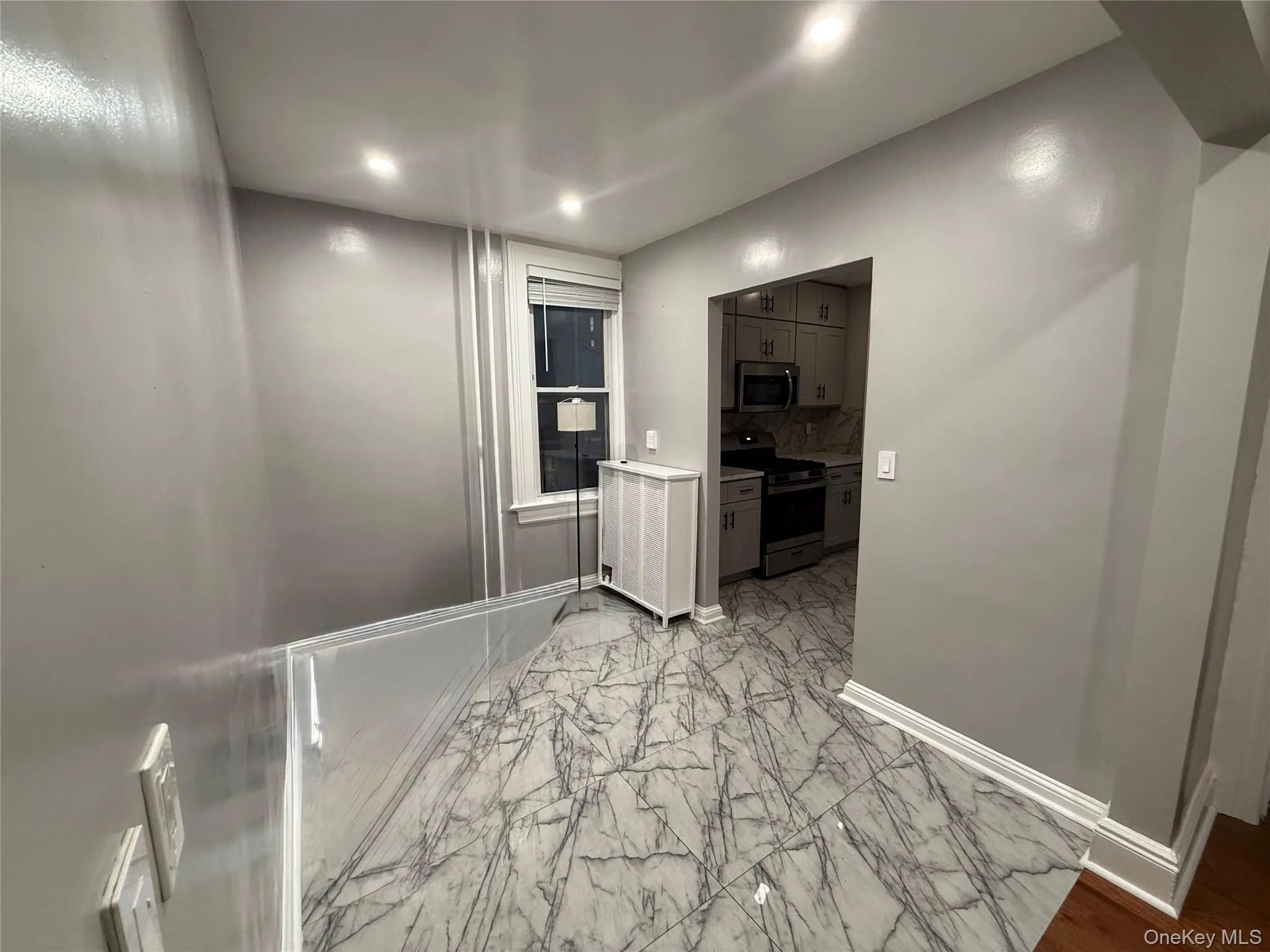Corridor featuring light marble finish floors and recessed lighting Corridor featuring light marble finish floors and recessed lighting