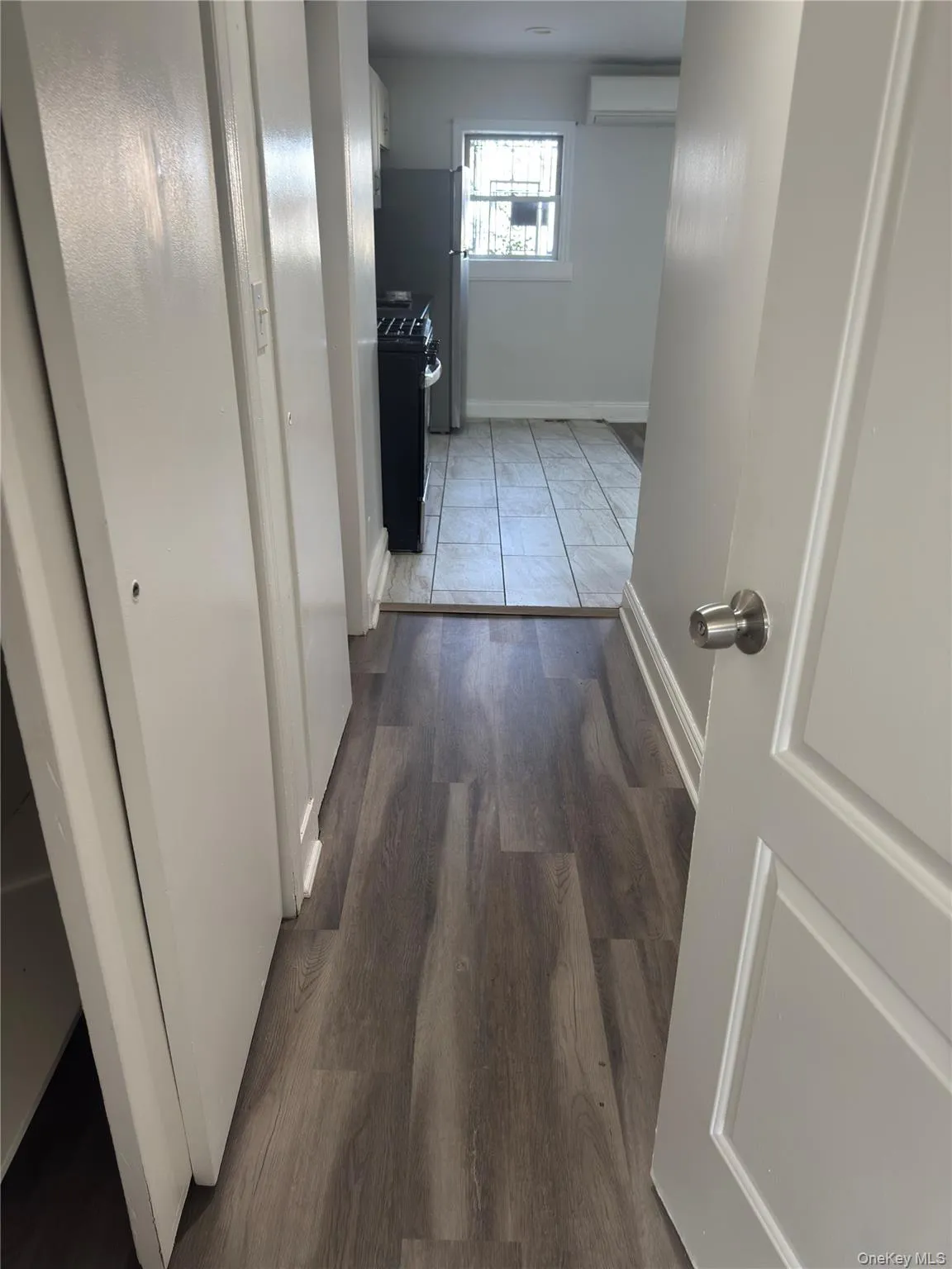 Hall with dark wood-style floors and a wall unit AC Hall with dark wood-style floors and a wall unit AC