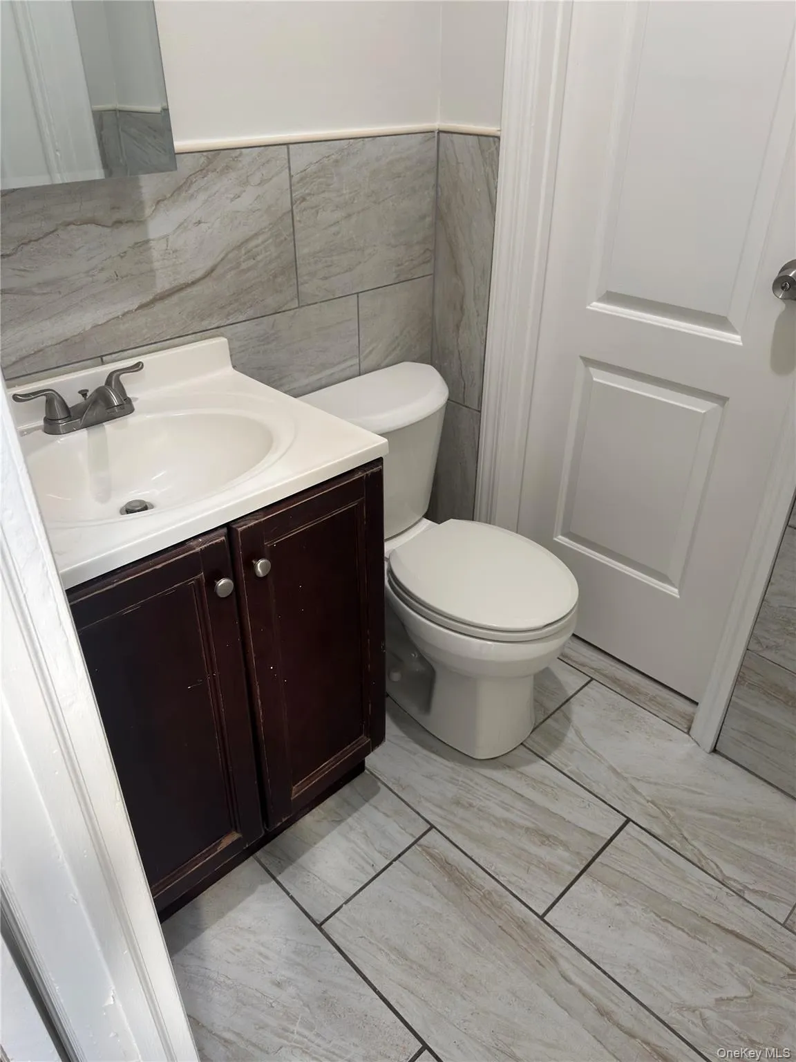 Half bath featuring vanity and tile walls Half bath featuring vanity and tile walls