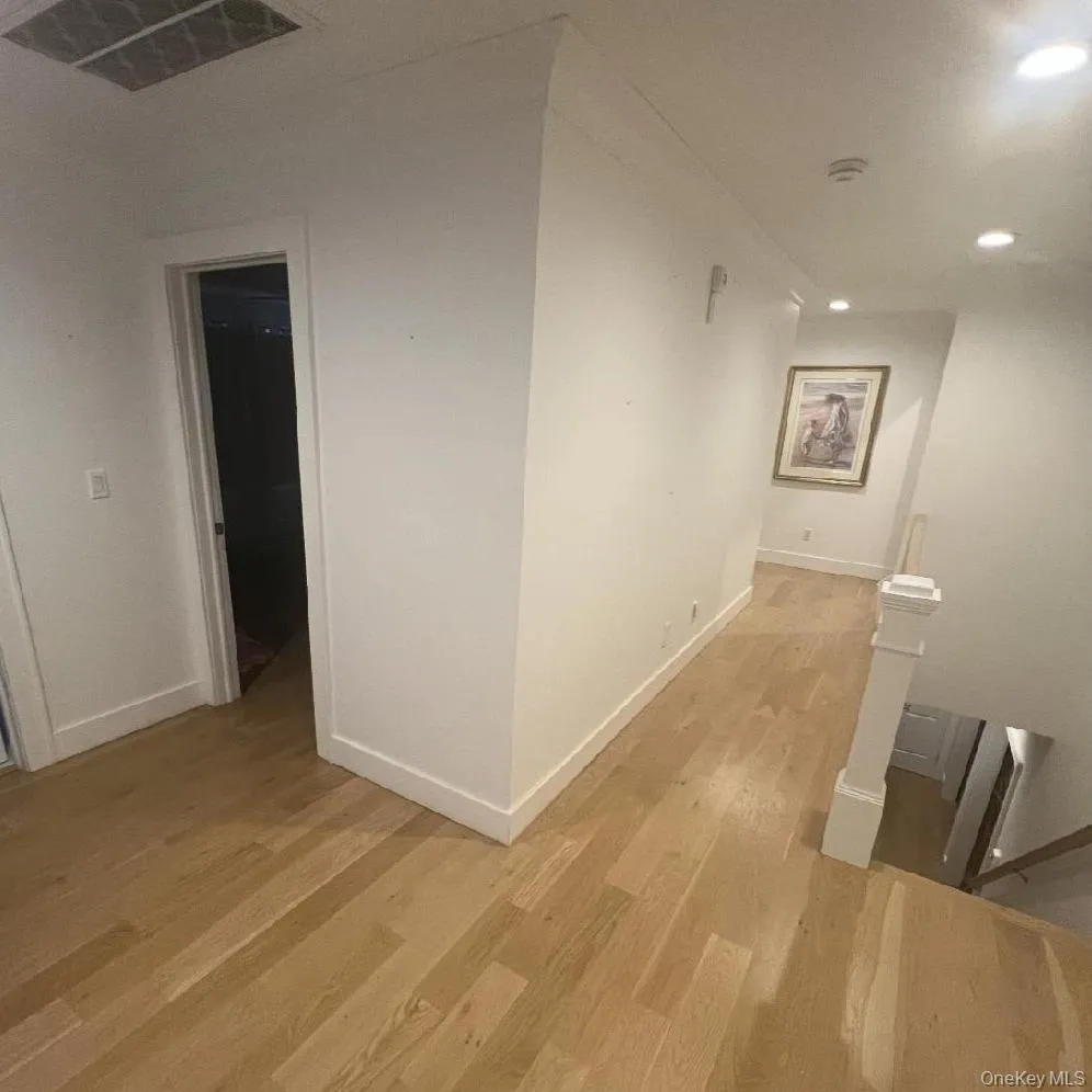 Hall with light wood-style flooring, recessed lighting, and an upstairs landing Hall with light wood-style flooring, recessed lighting, and an upstairs landing