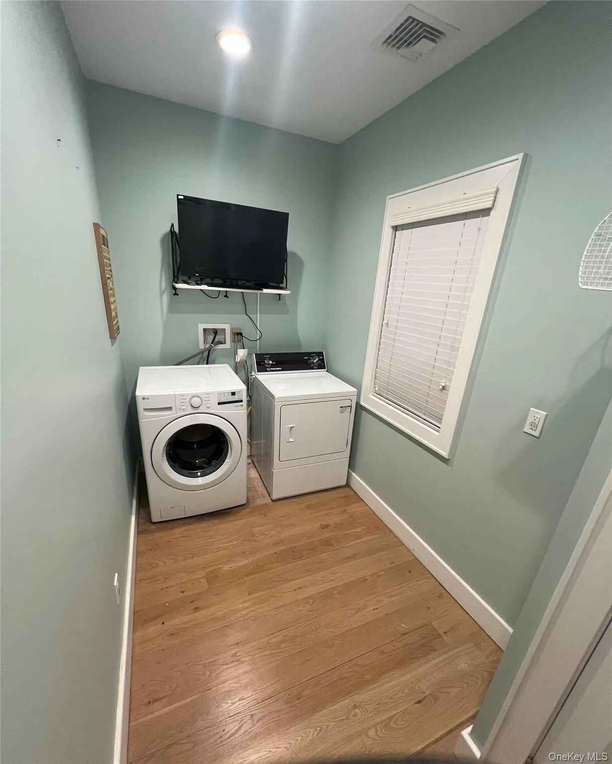 Washroom featuring light wood-type flooring and washer and clothes dryer Washroom featuring light wood-type flooring and washer and clothes dryer