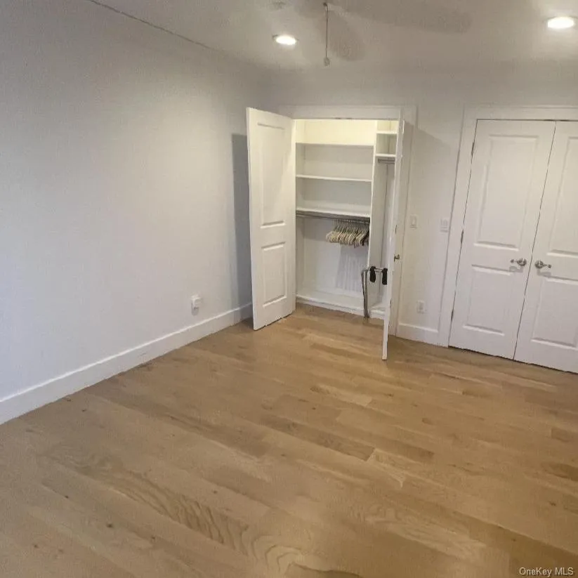 Unfurnished bedroom with light wood-type flooring, recessed lighting, two closets, and a ceiling fan Unfurnished bedroom with light wood-type flooring, recessed lighting, two closets, and a ceiling fan