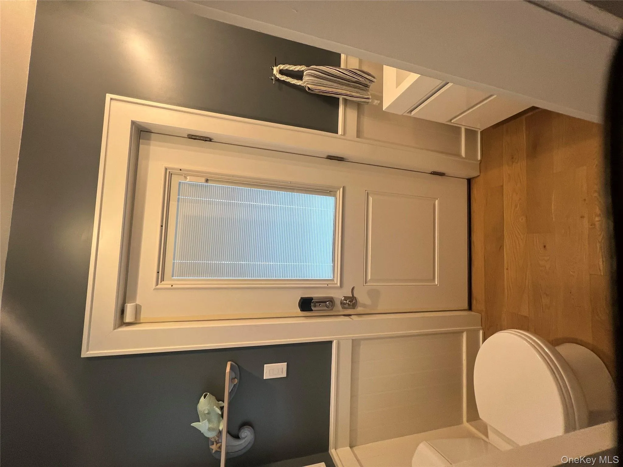 Half bathroom with vanity, a wainscoted wall, and light wood finished floors Half bathroom with vanity, a wainscoted wall, and light wood finished floors