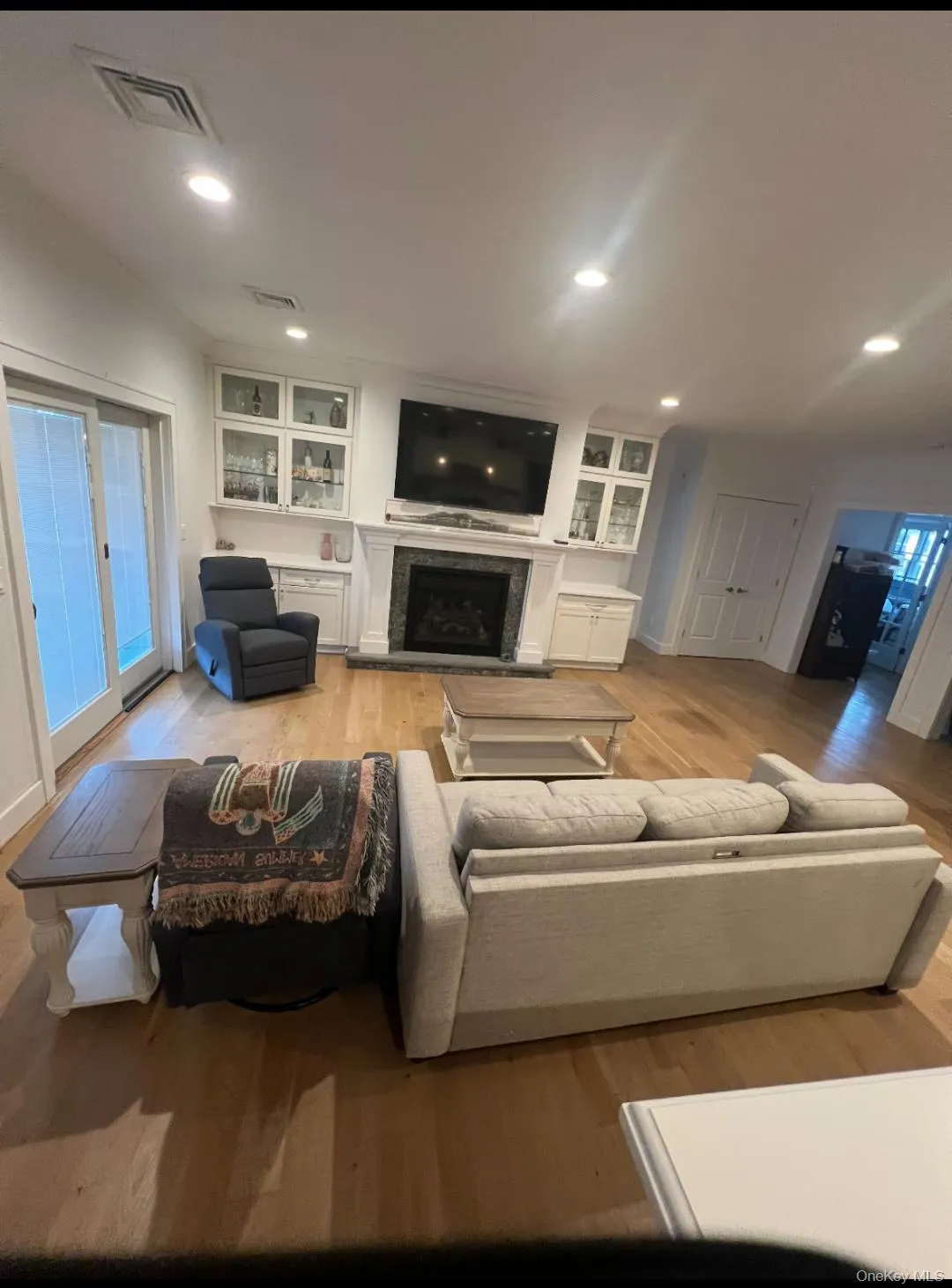 Living room with light wood finished floors, a premium fireplace, and recessed lighting Living room with light wood finished floors, a premium fireplace, and recessed lighting