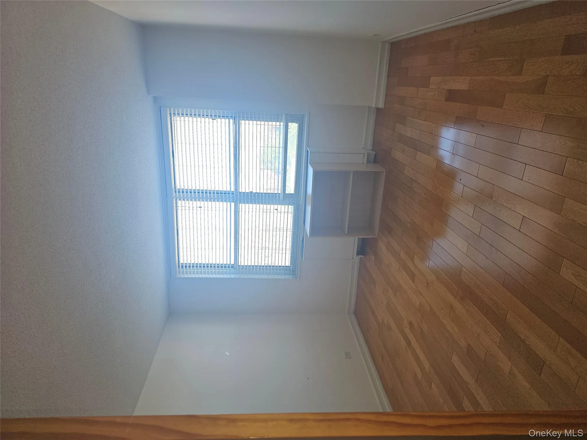 Spare room with a textured ceiling and dark wood-style flooring Spare room with a textured ceiling and dark wood-style flooring